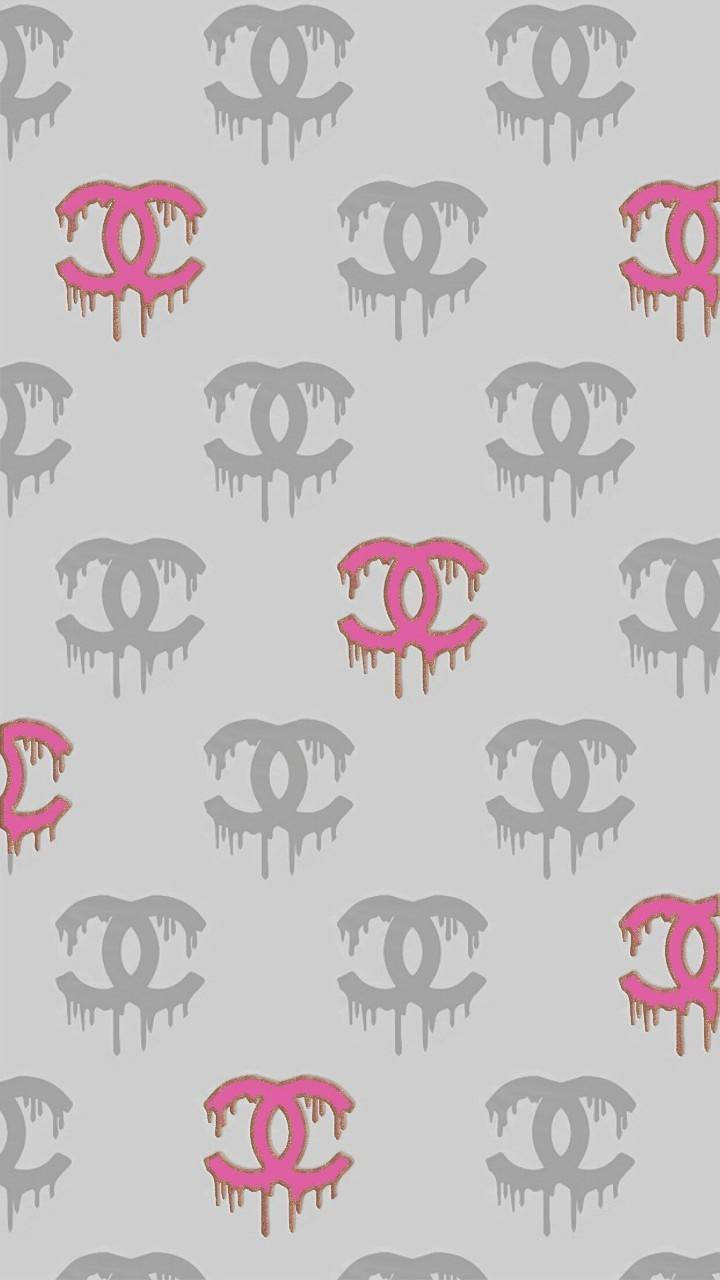 Chanel 桌布 壁紙 — 在淺灰色背景上，粉紅色和灰色的滴落香奈兒標誌重複圖案。
