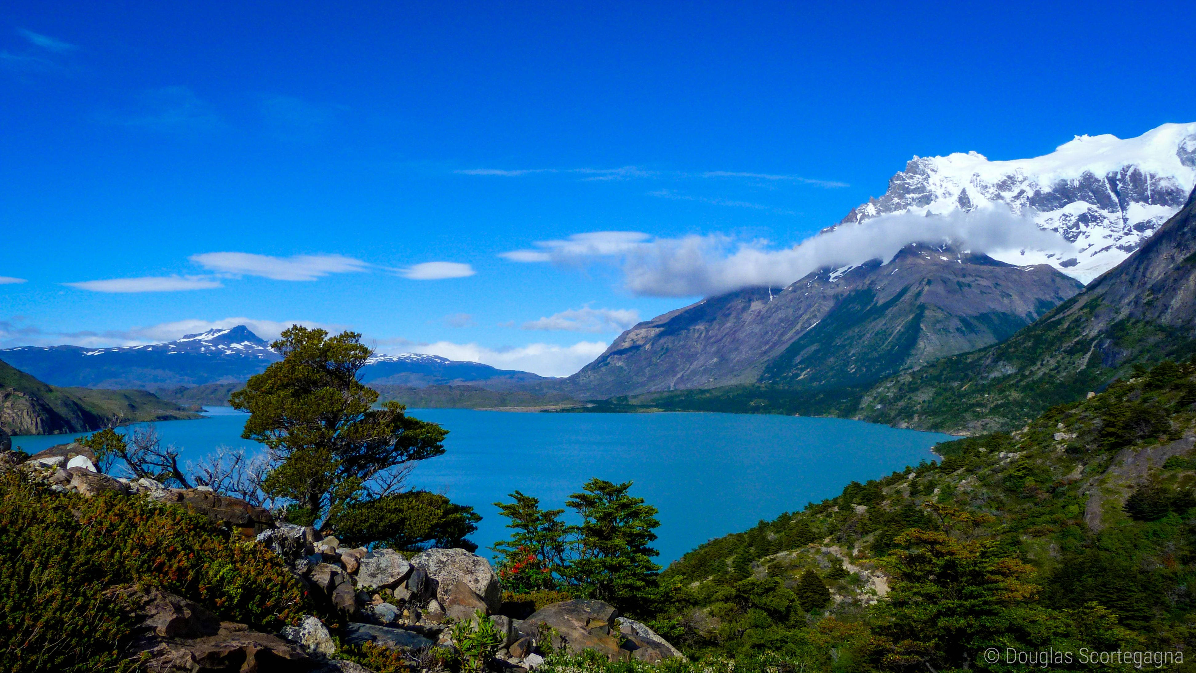 Lake 桌布 壁紙 — 在清澈的藍天下，一個充滿活力的藍綠色湖泊坐落在崎嶇的山脈之間，山頂覆蓋著白雪。