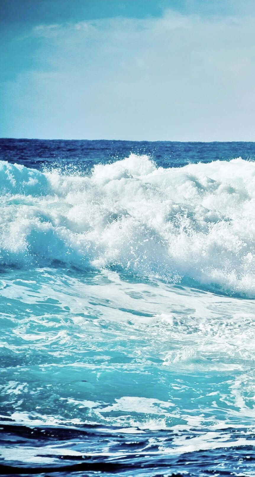 waves 桌布 壁紙 — 在清澈的藍天下，強勁的藍綠色海浪拍打著白色泡沫。