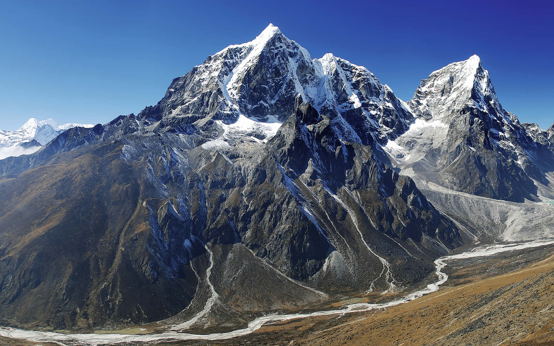 Mount Everest 桌布 壁紙 — 在清澈的藍天下，雄偉的雪山山脈擁有尖銳的山峰和崎嶇的山坡。