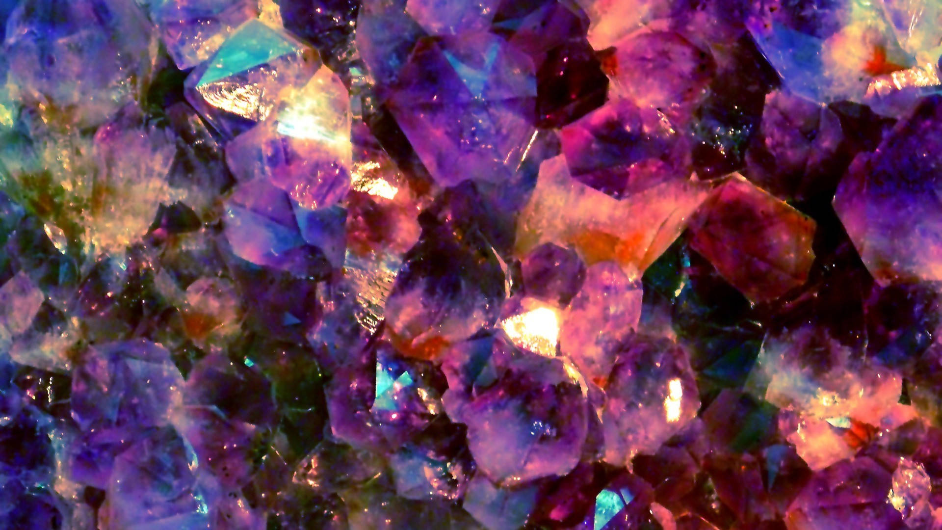 水晶 桌布 壁紙 — 在溫暖光線下閃爍的紫水晶近距離特寫，呈現充滿活力的紫色、藍色和粉紅色調。