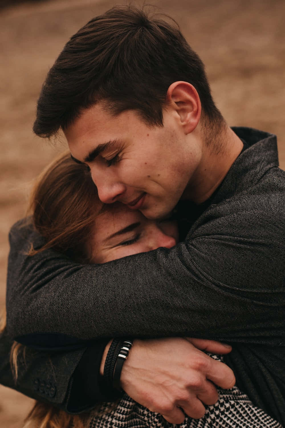 Hug 桌布 壁紙 — 在溫暖的金色光芒中，一男一女閉上眼睛溫柔擁抱。