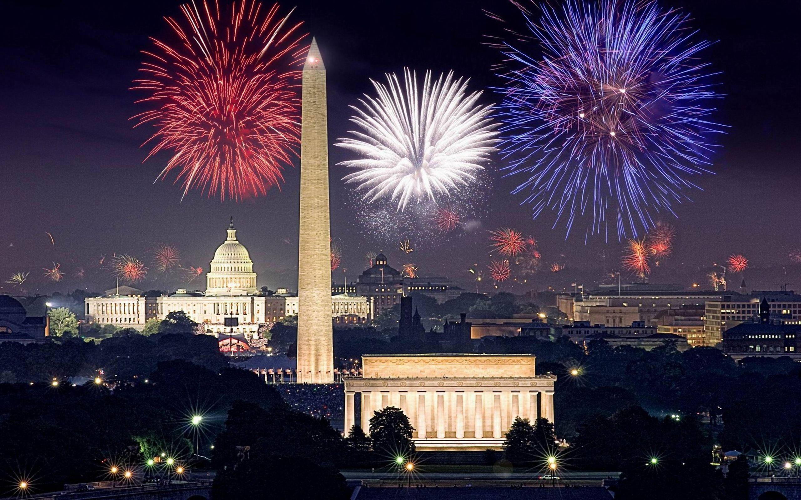 Washington 桌布 壁紙 — 在漆黑的夜空下，華盛頓特區的標誌性紀念碑上空綻放著鮮豔的煙火。