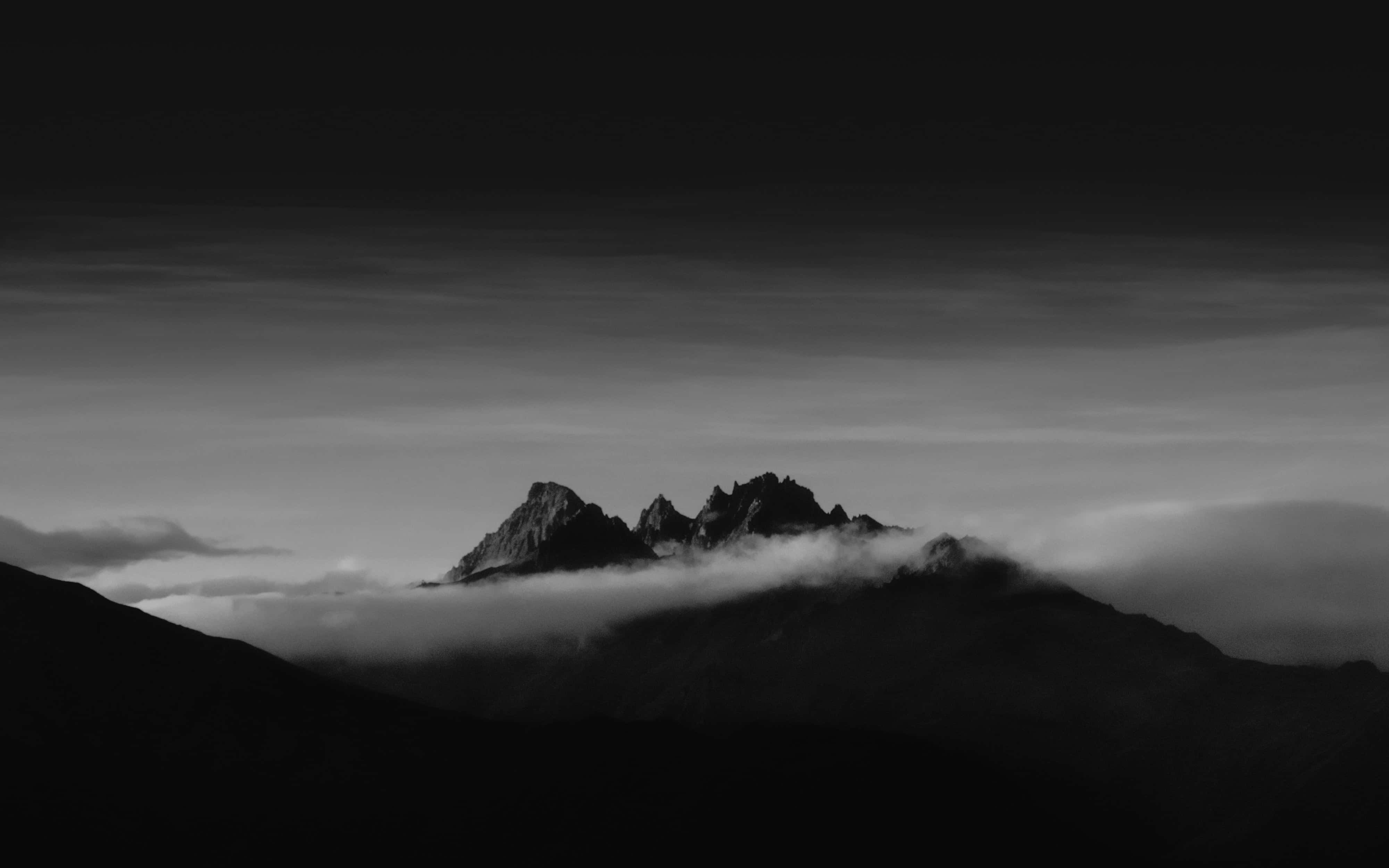 Dark Mountain 桌布 壁紙 — 在漸層天空下，一座黑白分明的山峰刺穿雲海。