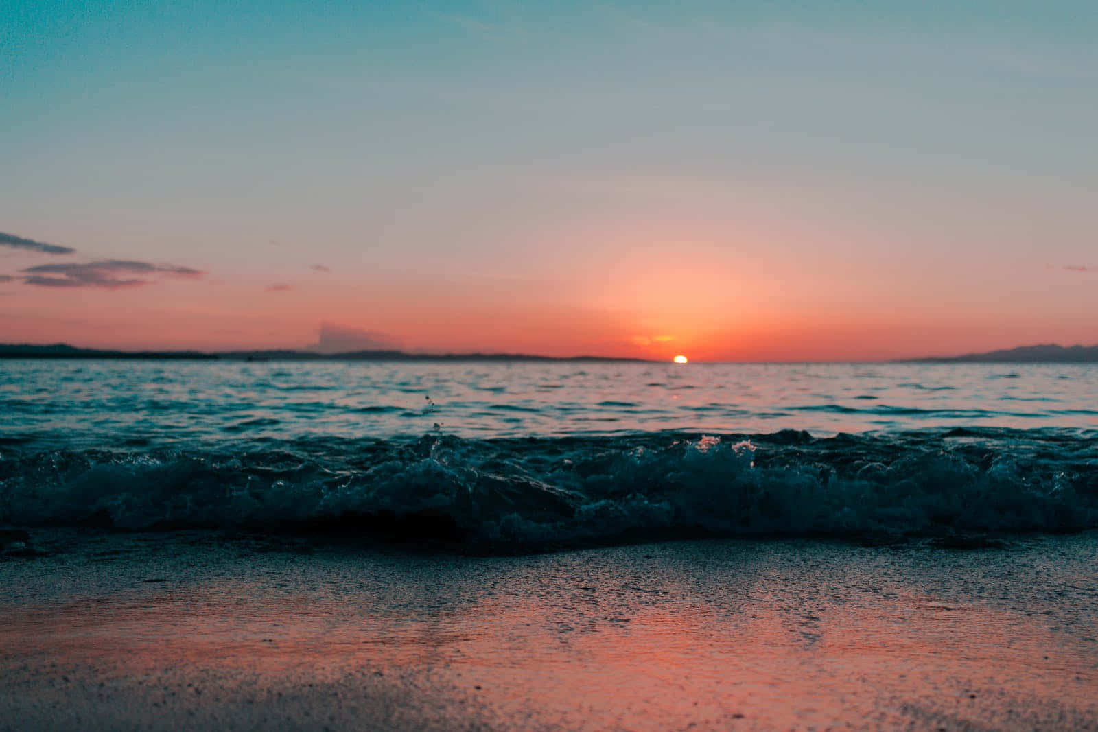 Cute Sunset 桌布 壁紙 — 在漸變色的天空下，平靜的海面上夕陽西沉，溫柔的波浪拍打著沙灘。