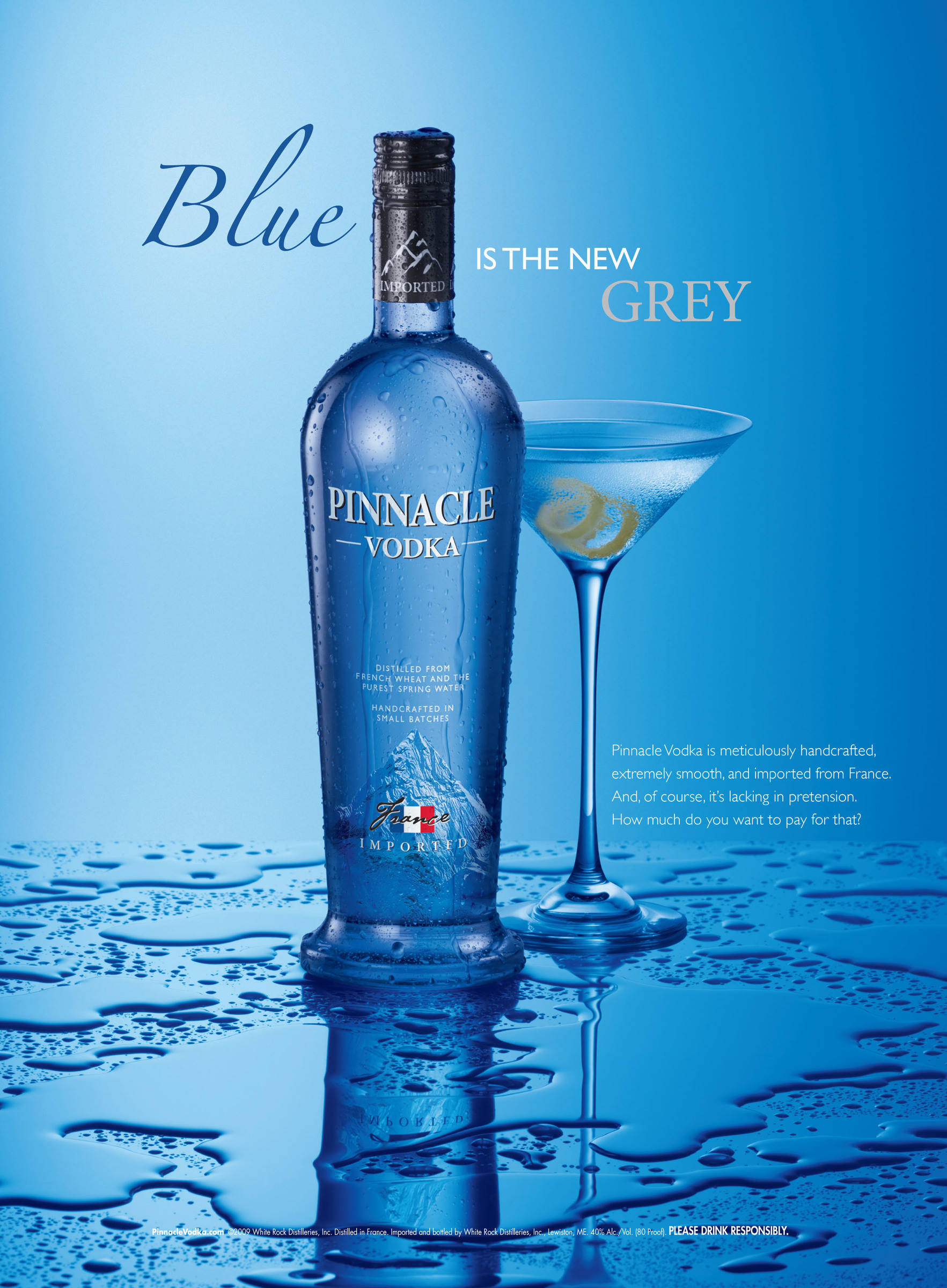 bottle 桌布 壁紙 — 在漸變藍色背景下的潮濕反光表面上，一個時尚的藍色Pinnacle Vodka酒瓶旁邊放著一個馬丁尼杯。