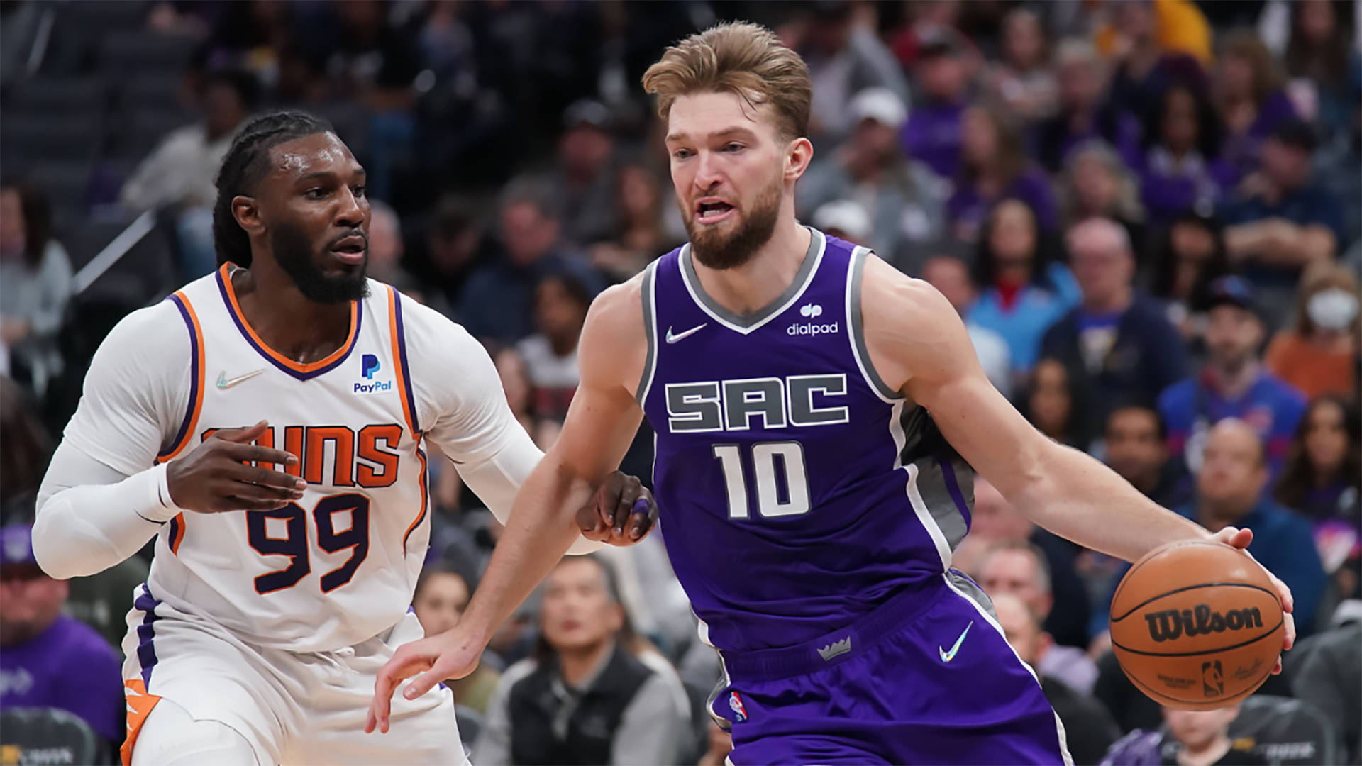 domantas sabonis 桌布 壁紙 — 在激烈的NBA比賽中，沙加緬度國王隊球員運球，同時被鳳凰城太陽隊球員緊密防守。