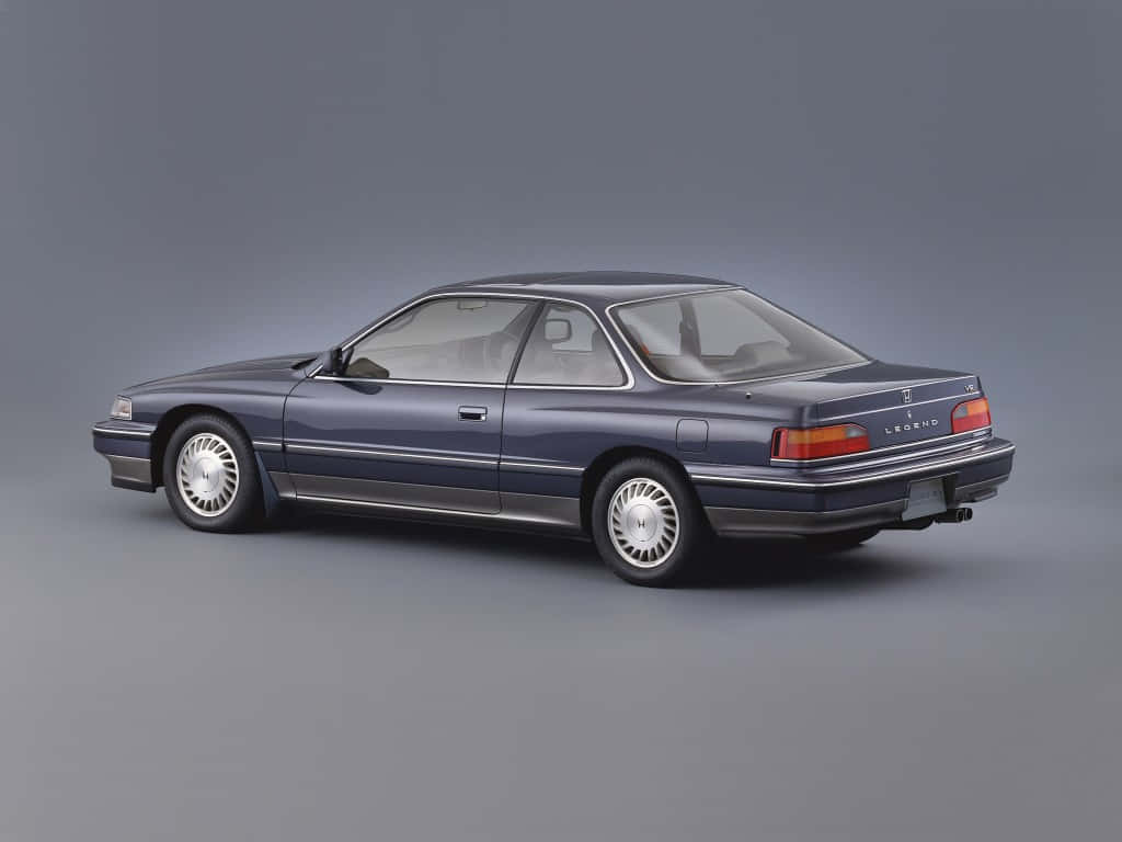Honda Legend 桌布 壁紙 — 在灰色中性攝影棚背景前展示側面的時尚深藍色本田Legend轎跑車。