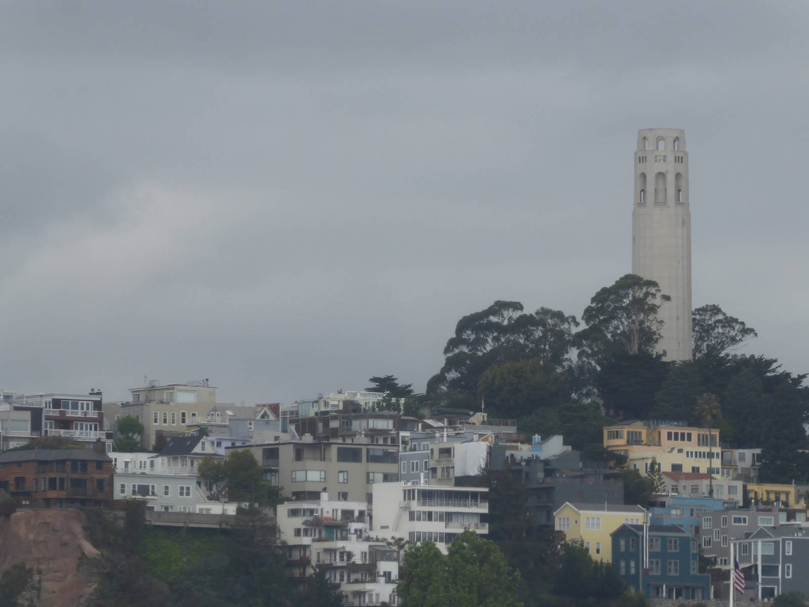 Gloomy 桌布 壁紙 — 在灰色陰天之下，科伊特塔聳立於舊金山色彩繽紛的密集房屋山坡之上。