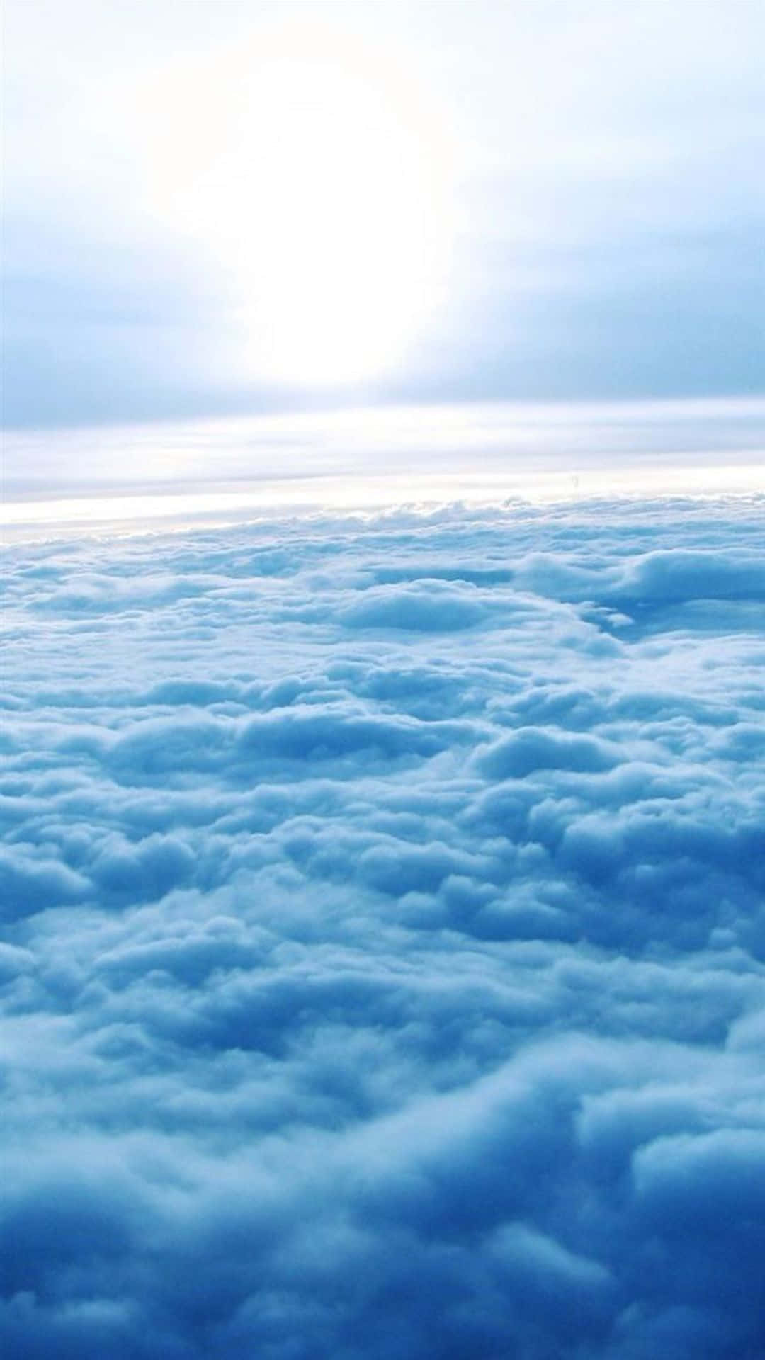 雲朵 桌布 壁紙 — 在無盡的藍色雲層之上，明亮的太陽在天空中閃耀的寧靜航拍視圖。