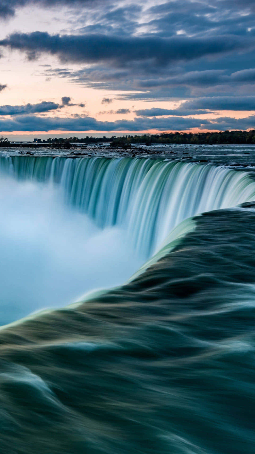 720p Niagara Falls 桌布 壁紙 — 在粉紅色和藍色雲彩的暮色天空下，雄偉的瀑布以慢動作傾瀉而下。