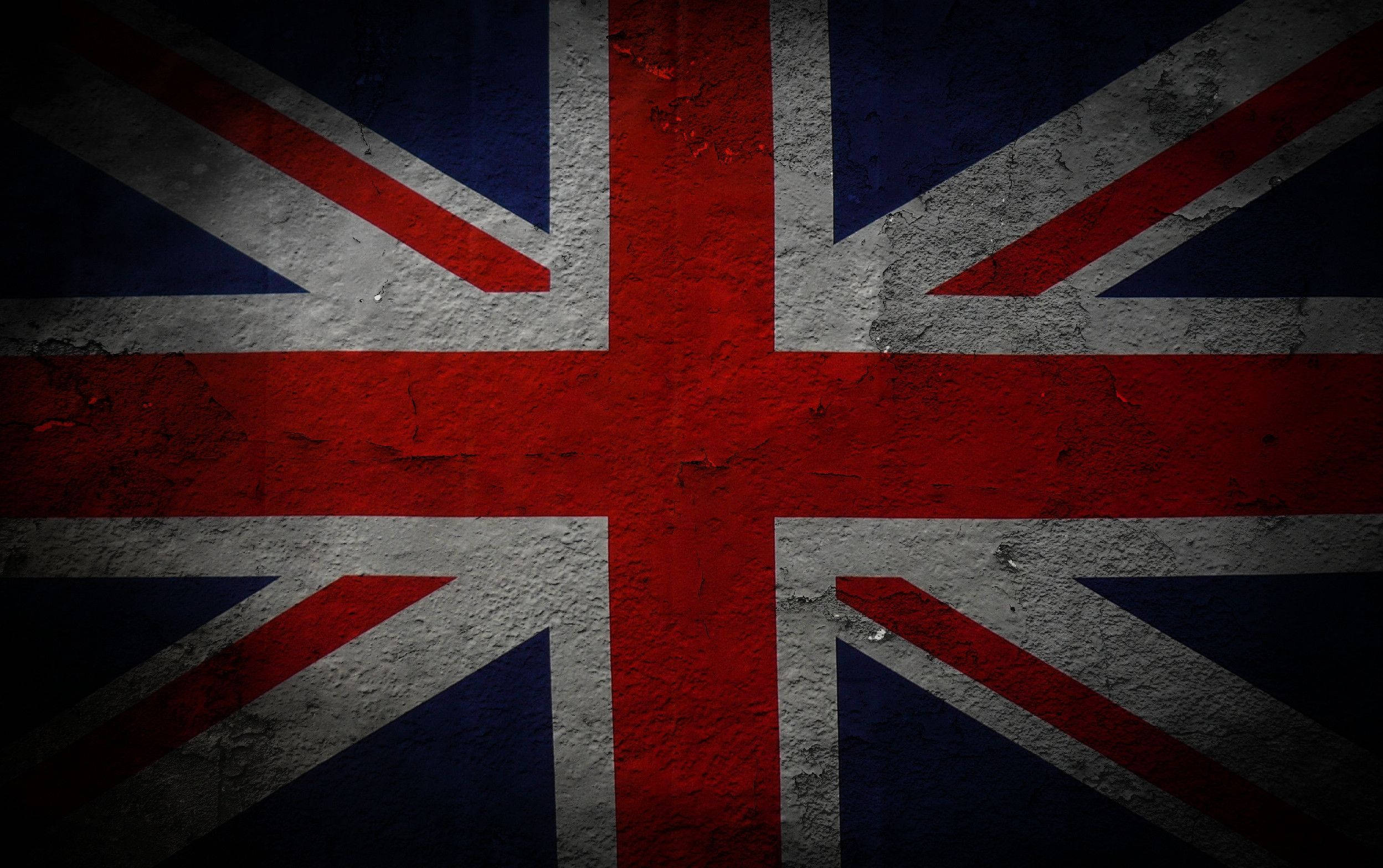 United Kingdom Flag 桌布 壁紙 — 在粗糙紋理的混凝土牆上繪製的英國國旗，帶有風化油漆和暗色暈影邊緣。