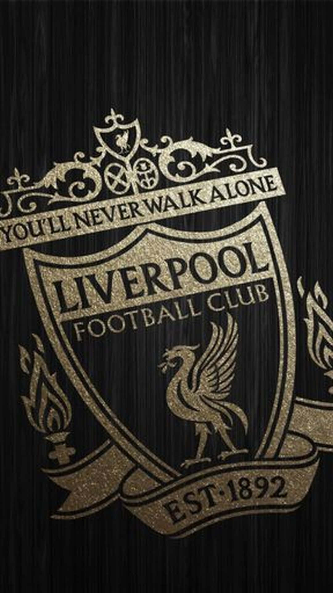 Liverpool iPhone 桌布 壁紙 — 在紋理黑色木質背景上，閃閃發光的金色利物浦足球俱樂部徽章，附有格言「You'll Never Walk Alone」。