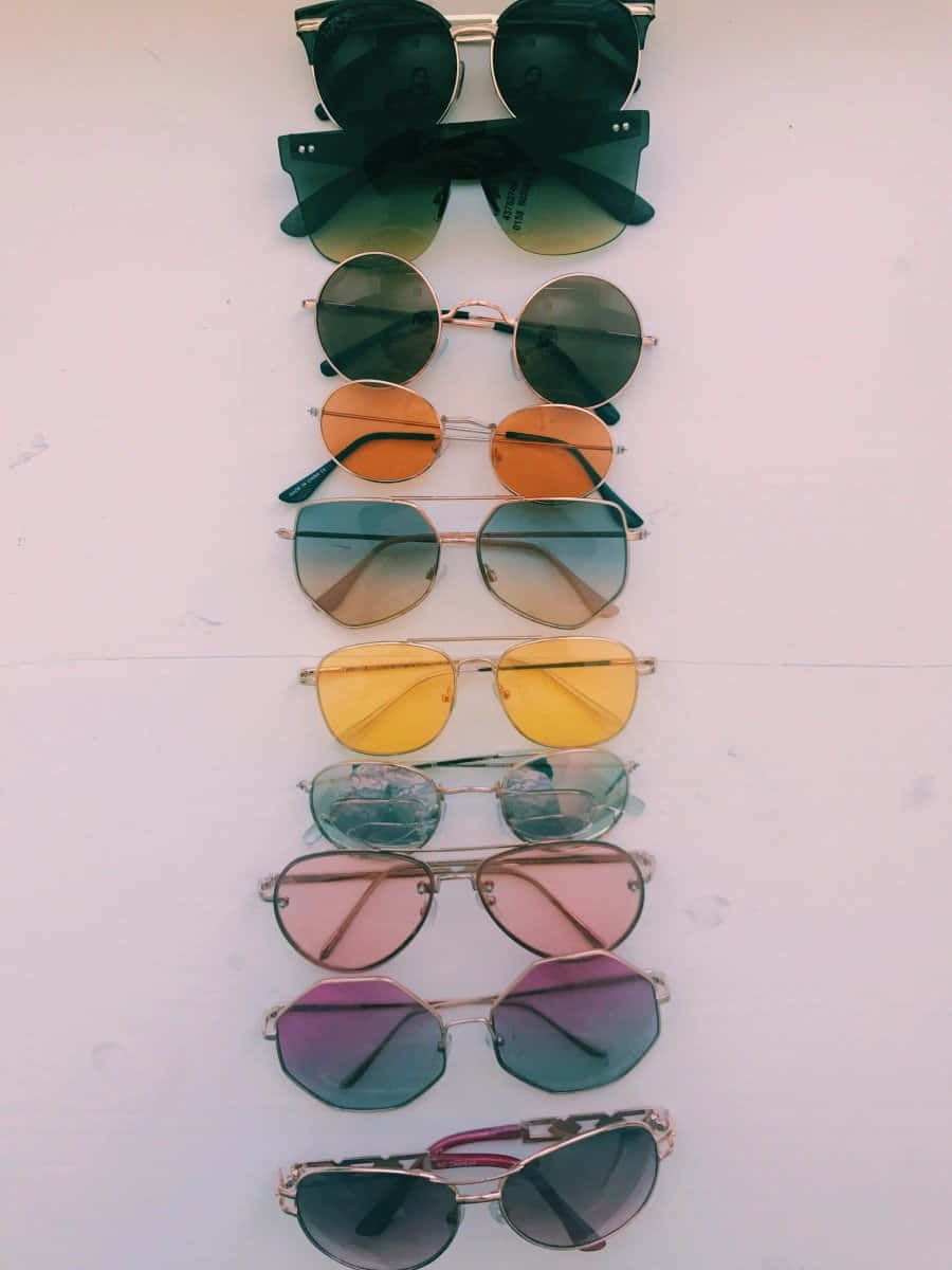 Sunglasses 桌布 壁紙 — 在純白色表面上垂直排列的彩色太陽眼鏡，帶有漸變鏡片。