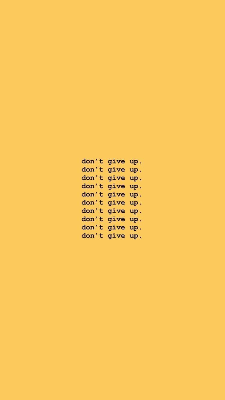 Yellow Baddie 桌布 壁紙 — 在純芥末黃色背景上以黑色重複「don't give up」的極簡勵志文字。
