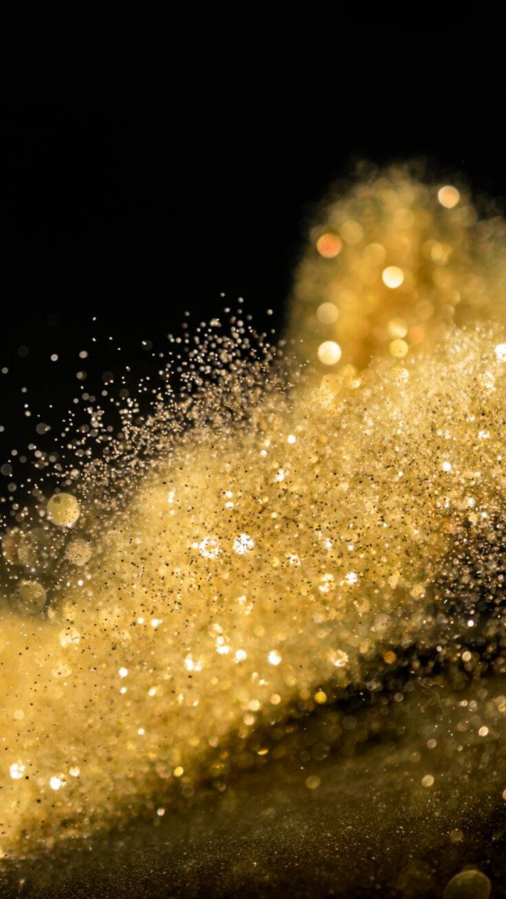Dust 桌布 壁紙 — 在純黑背景上，金色亮粉粒子動態爆炸，營造出閃爍的瀑布效果。