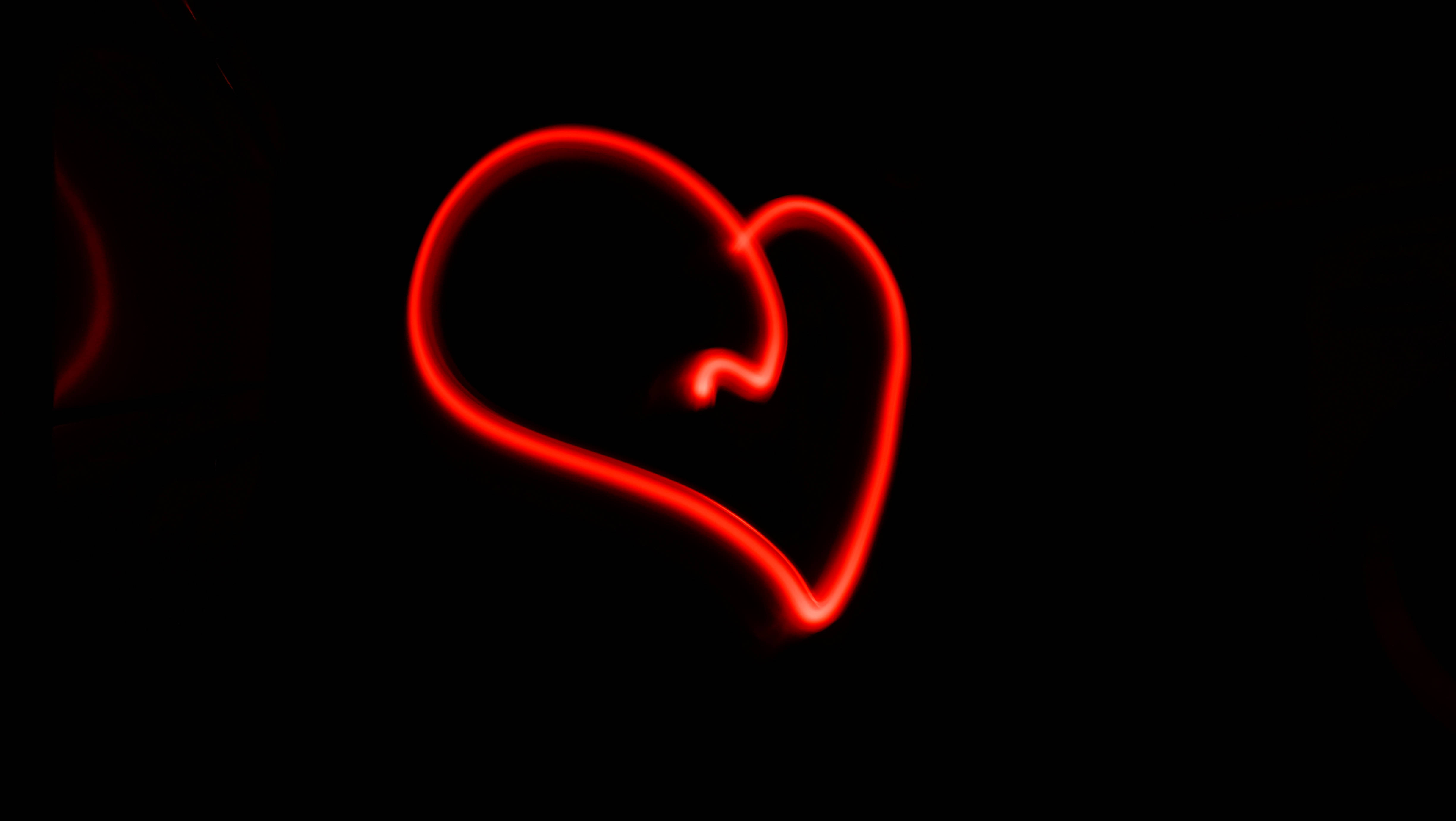 Dark Heart 桌布 壁紙 — 在純黑色背景上，以光跡繪製的發光紅色心形。