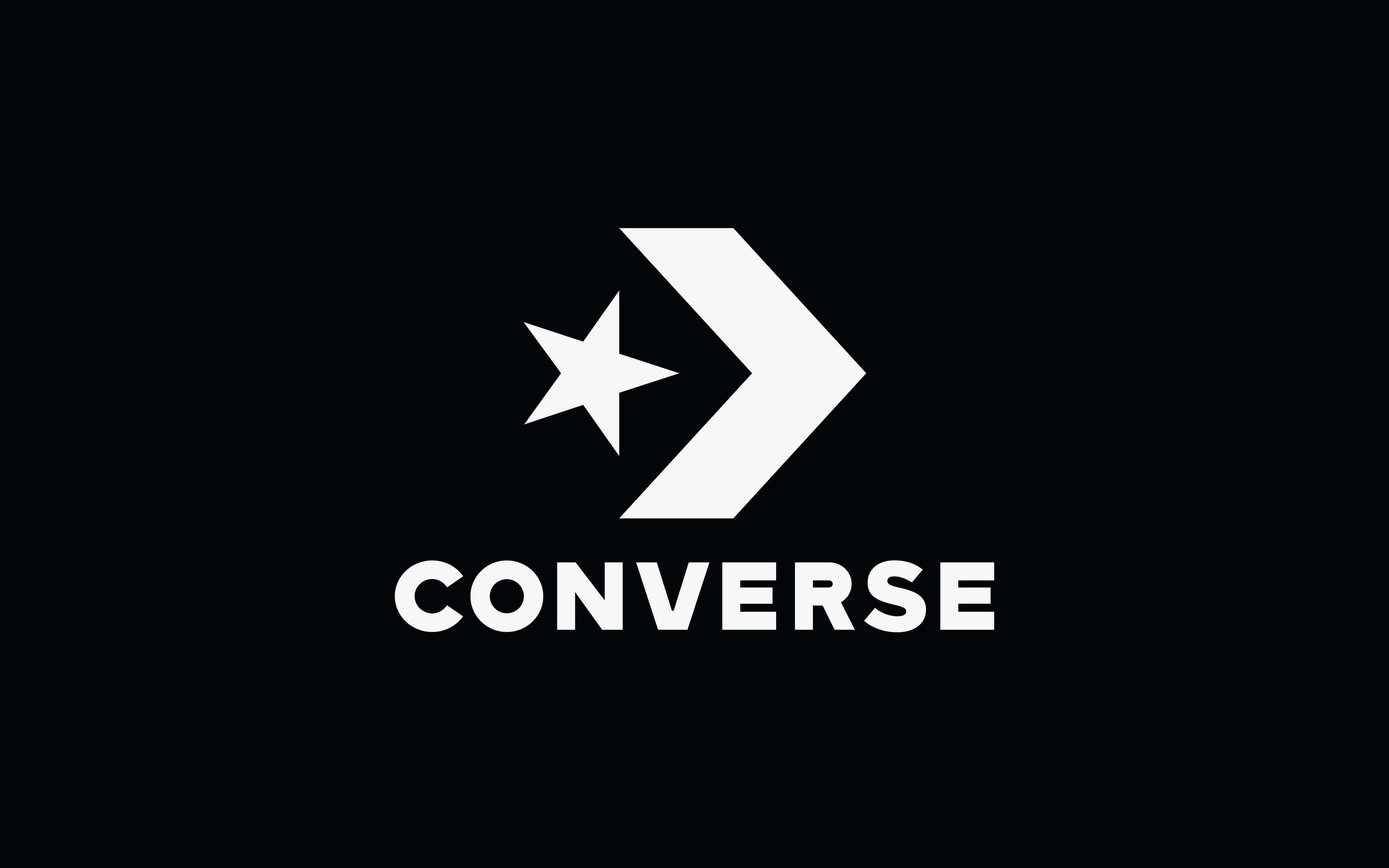 Converse 桌布 壁紙 — 在純黑色背景上，帶有星星和箭頭的醒目白色Converse標誌。