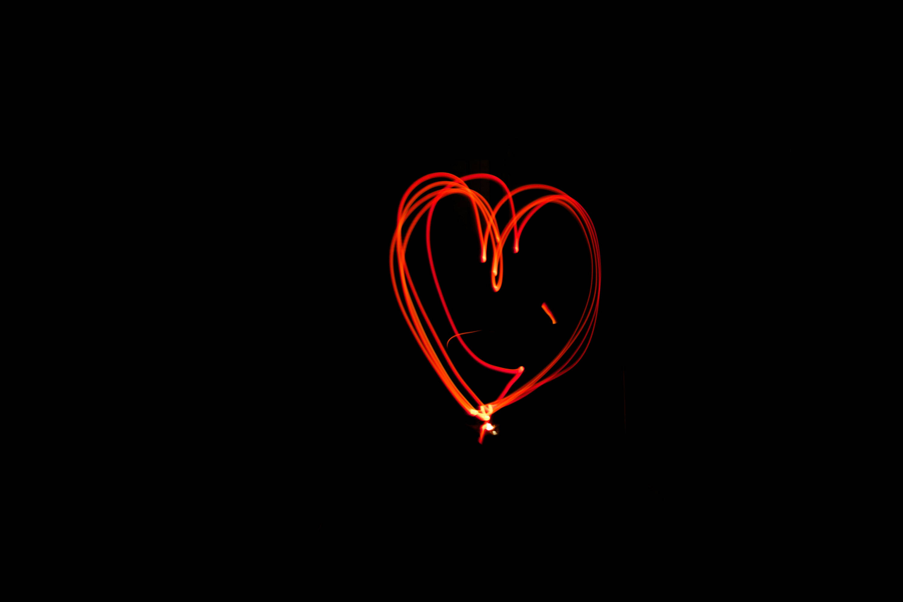 Dark Heart 桌布 壁紙 — 在純黑色背景上，用光跡繪製的發光紅色心形。