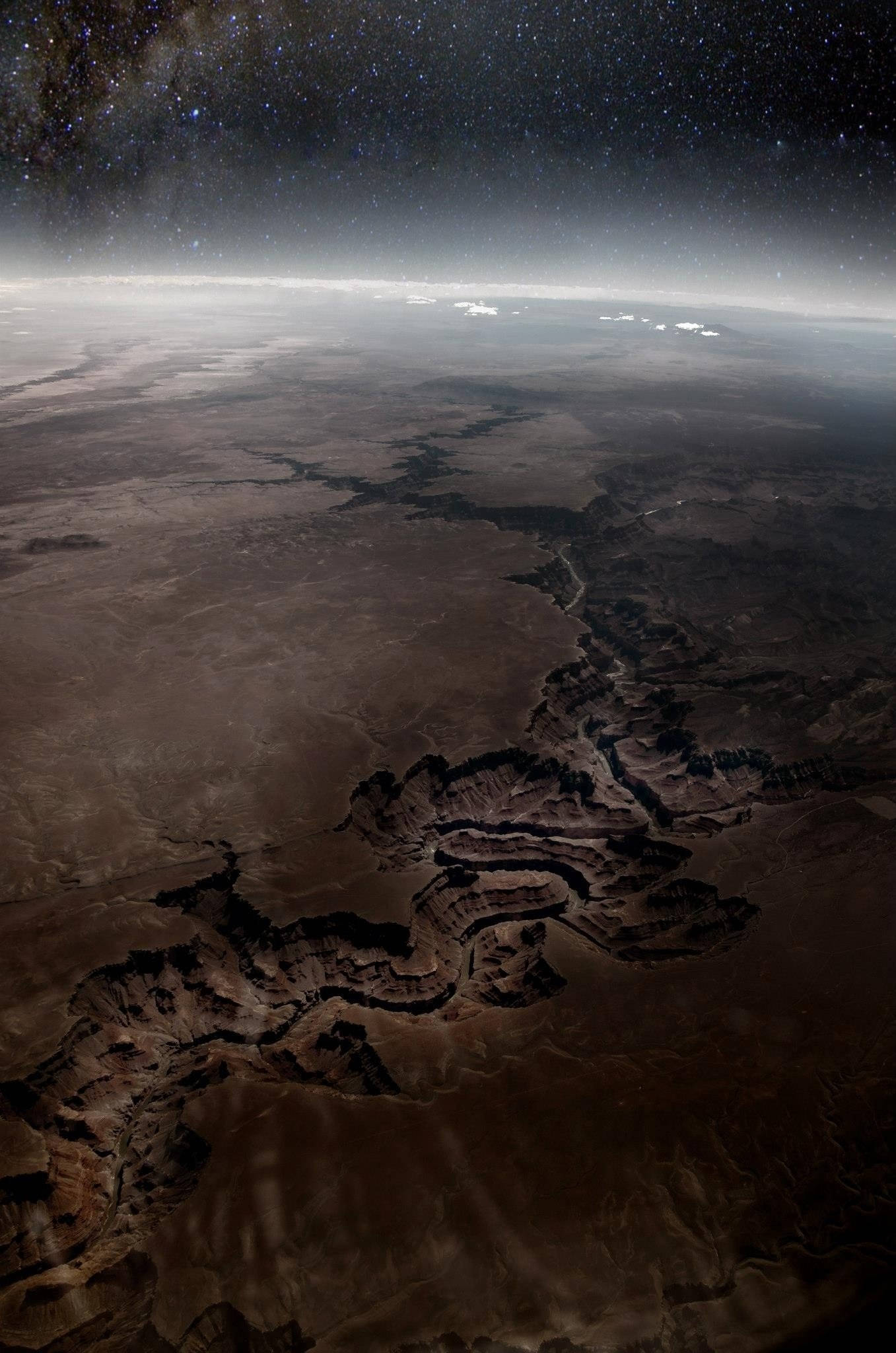 Canyon 桌布 壁紙 — 在繁星夜空下，一個廣闊峽谷系統的壯麗景色，地球的曲線清晰可見。