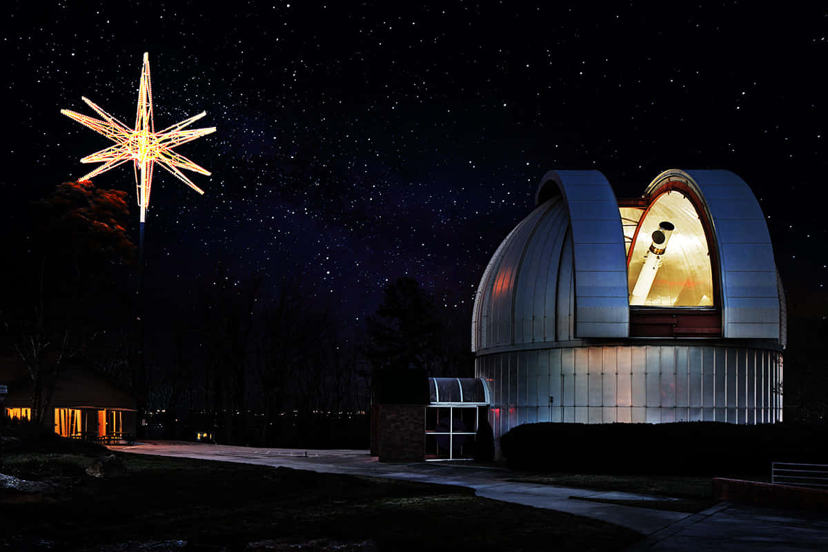 Observatory 桌布 壁紙 — 在繁星點點的夜空下，一個發光的星形燈飾矗立在圓頂天文台旁邊。