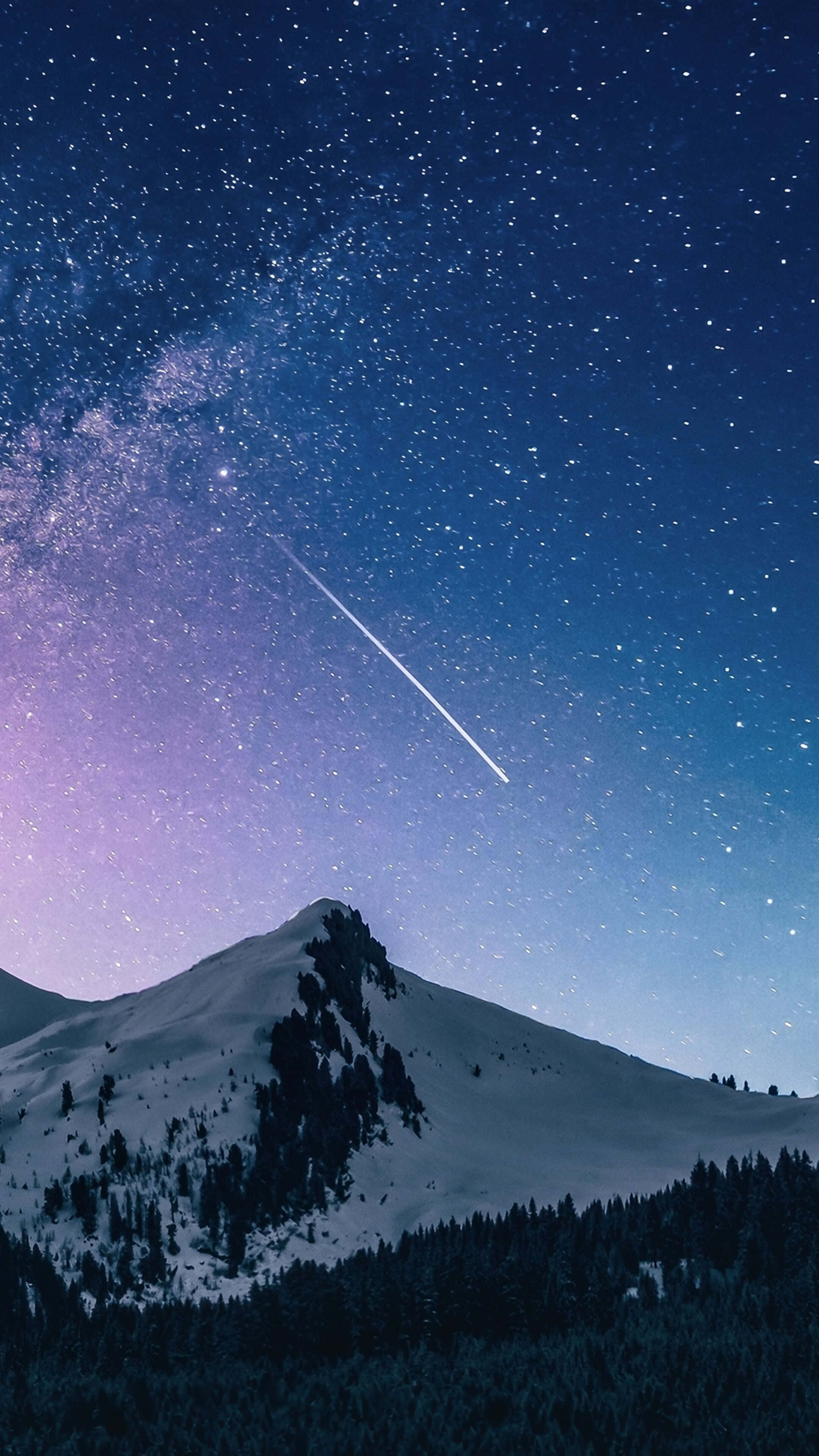 Starry Sky 桌布 壁紙 — 在繁星點點的夜空下，一座白雪覆蓋的山峰，一顆明亮的流星劃過銀河。