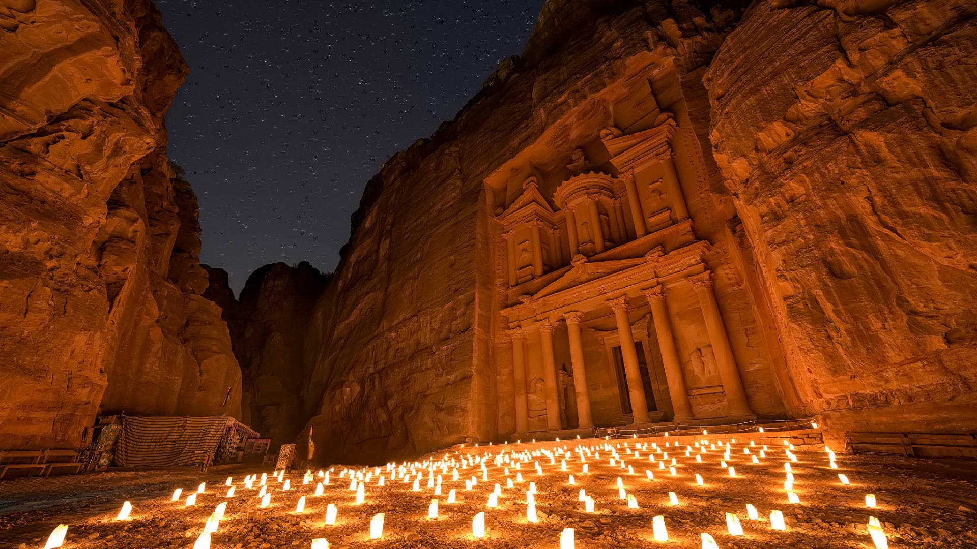 Jordan 桌布 壁紙 — 在繁星點點的夜空下，數千支蠟燭照亮了古老的佩特拉外牆。