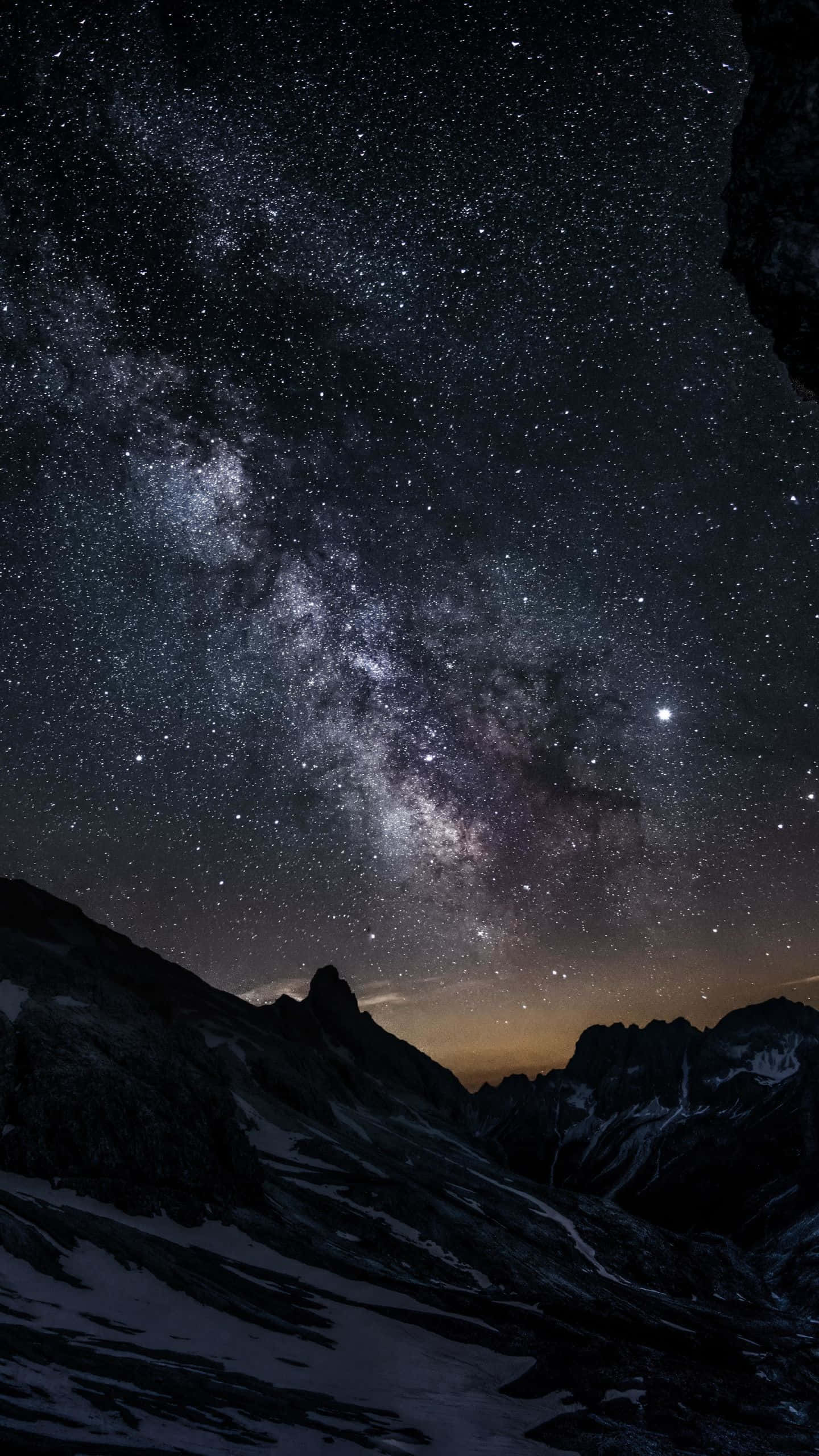 山景 桌布 壁紙 — 在繁星點點的夜空下，銀河橫跨積雪的山峰，景色令人嘆為觀止。