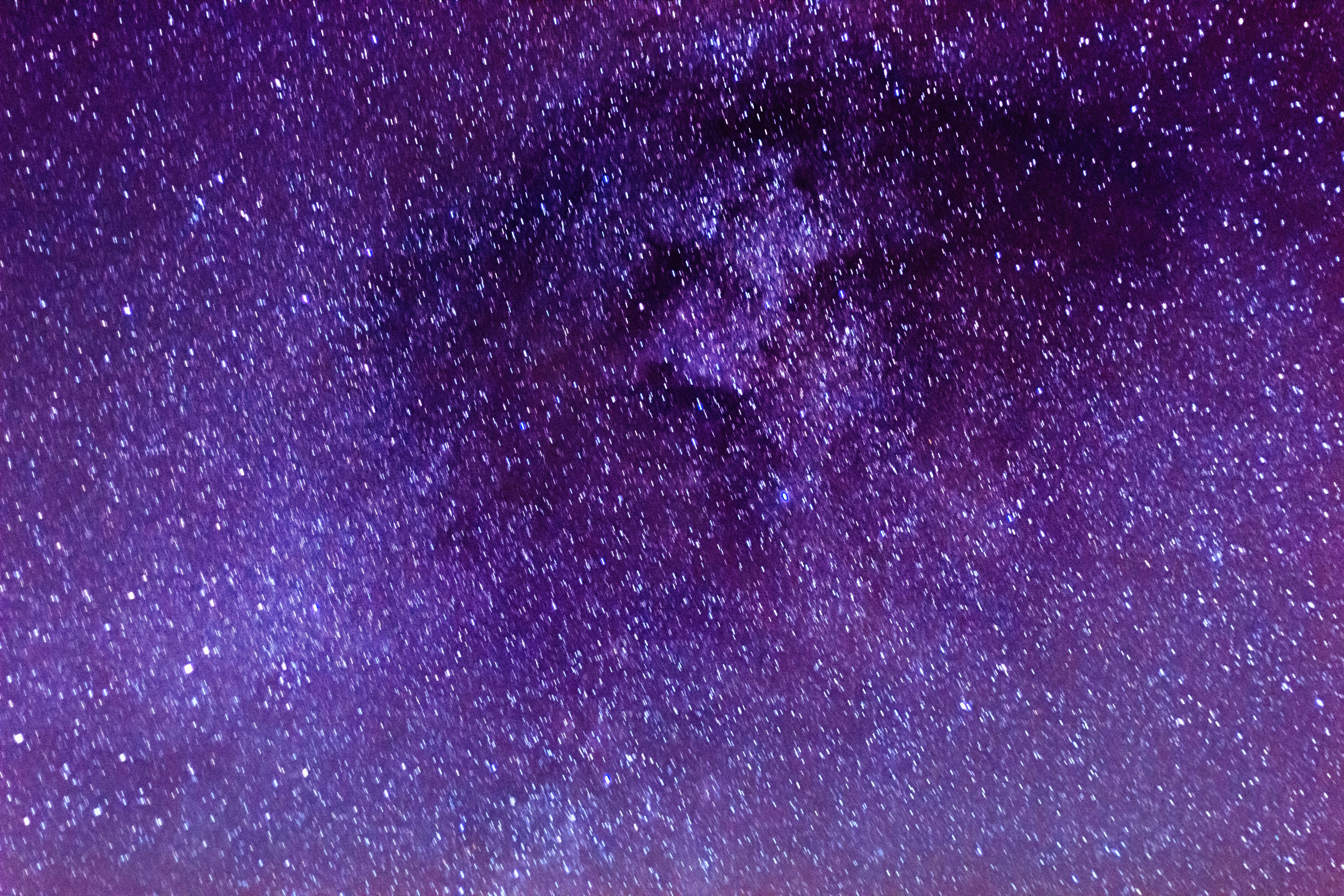 Dark Purple Desktop 桌布 壁紙 — 在繁星點點的夜空下，銀河系散發出深紫色和藍色光芒的壯麗景色。