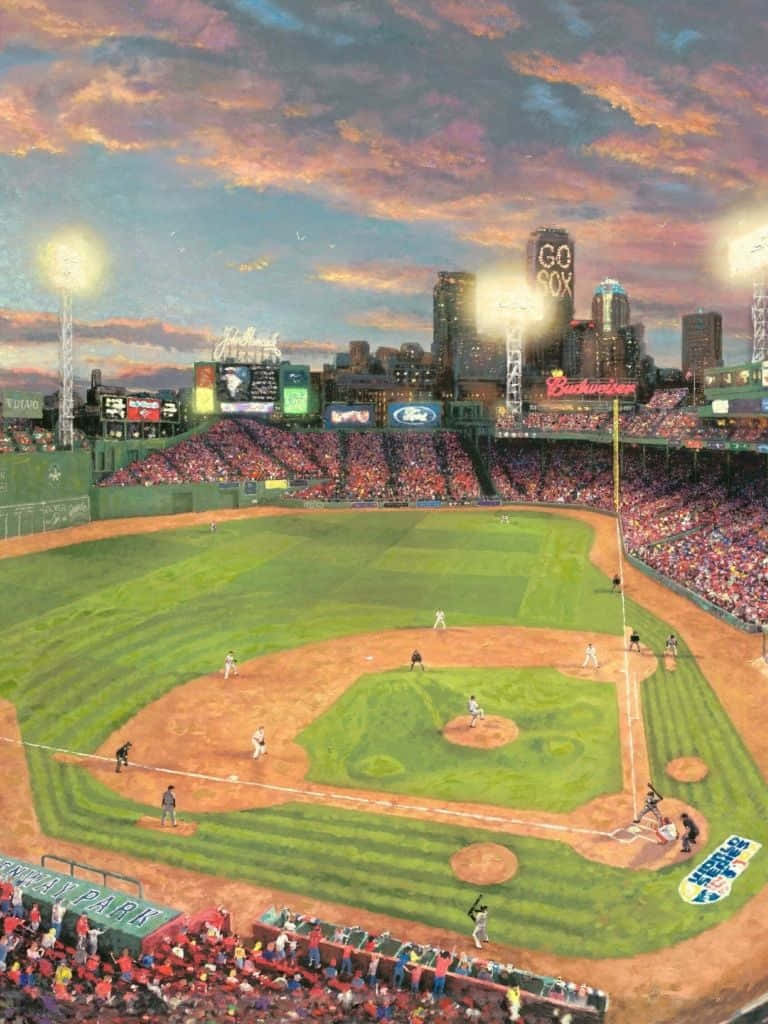 Baseball Stadium 桌布 壁紙 — 在芬威球場，一場充滿活力的棒球比賽在熾熱的日落天空下展開，背景是繁華的城市天際線。