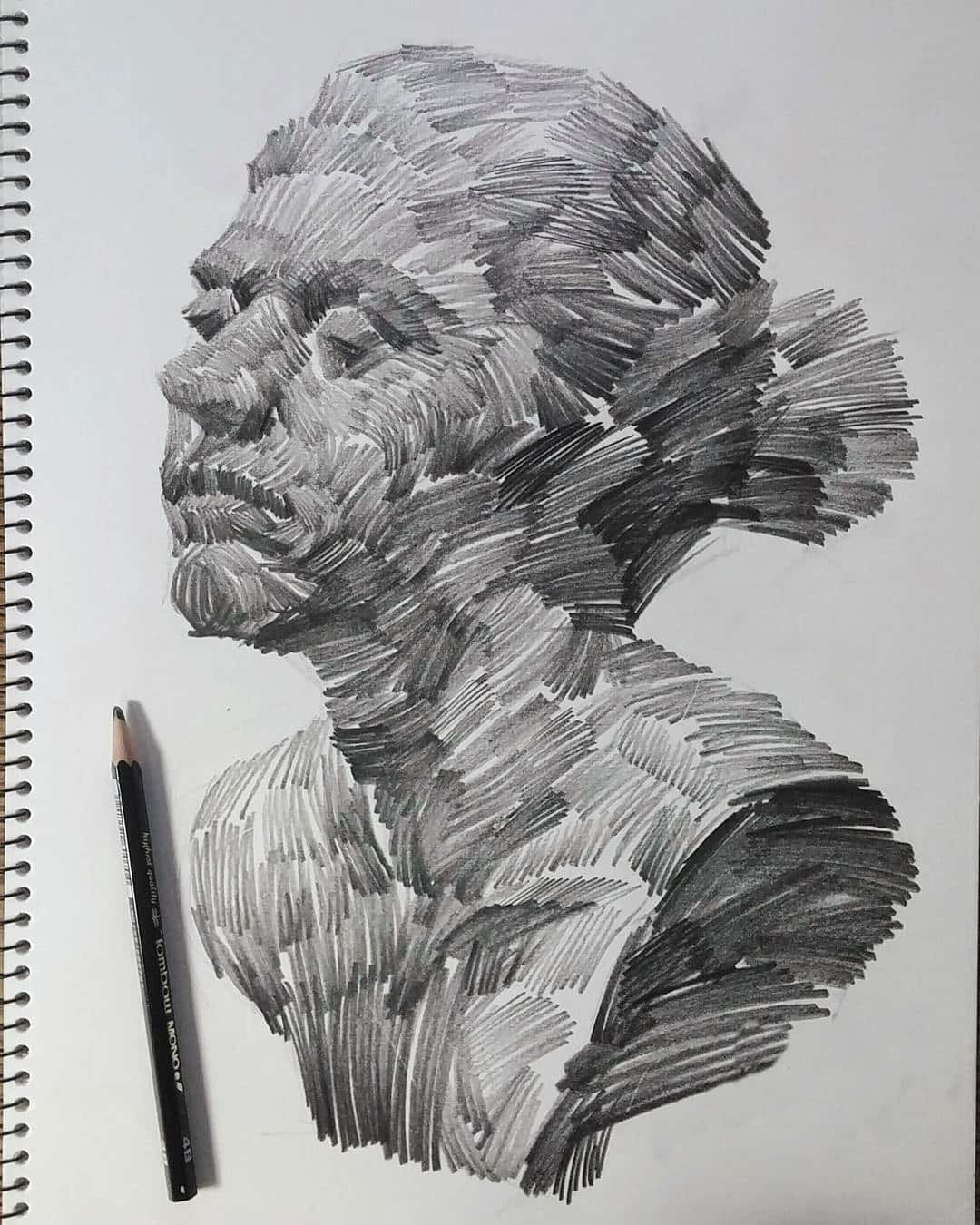 lines 桌布 壁紙 — 在螺旋筆記本紙上，石墨鉛筆旁邊，一個帶有紋理陰影的人體半身像的詳細鉛筆素描。