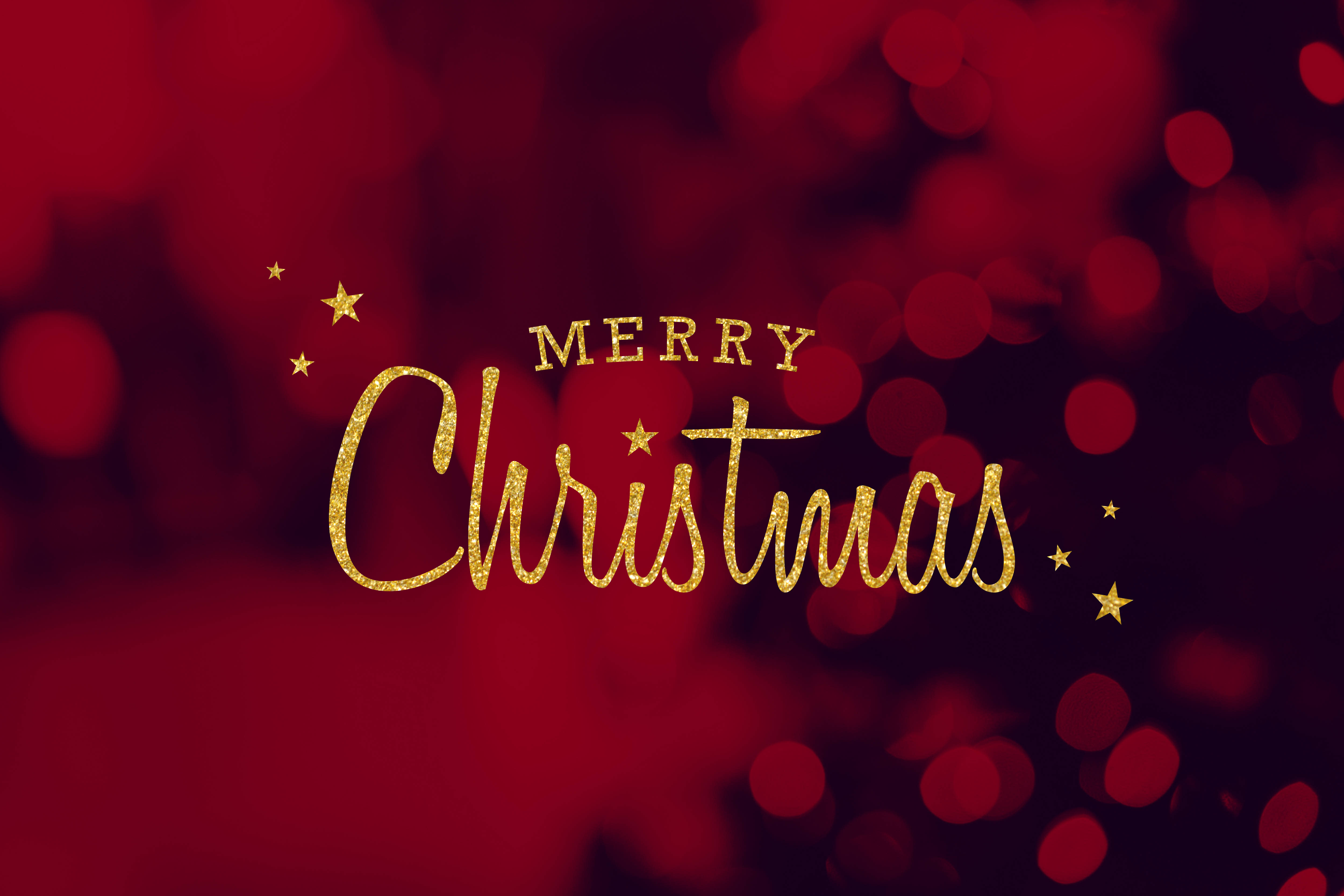 Red Christmas 桌布 壁紙 — 在豐富的紅色散景背景上，金色閃閃發光的「聖誕快樂」文字，伴隨著閃爍的星星。