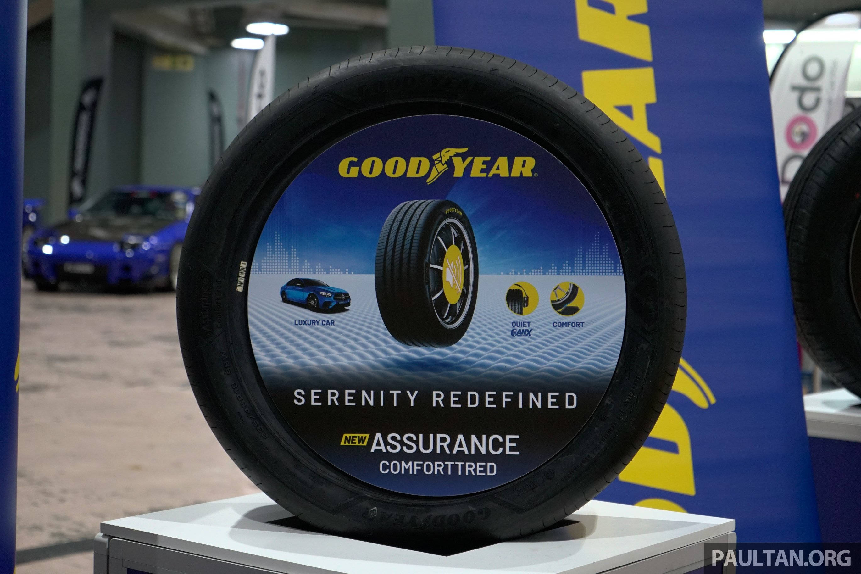 cars 桌布 壁紙 — 在車展上展示的Goodyear輪胎，包括一個帶有品牌和性能圖形的大型輪胎。