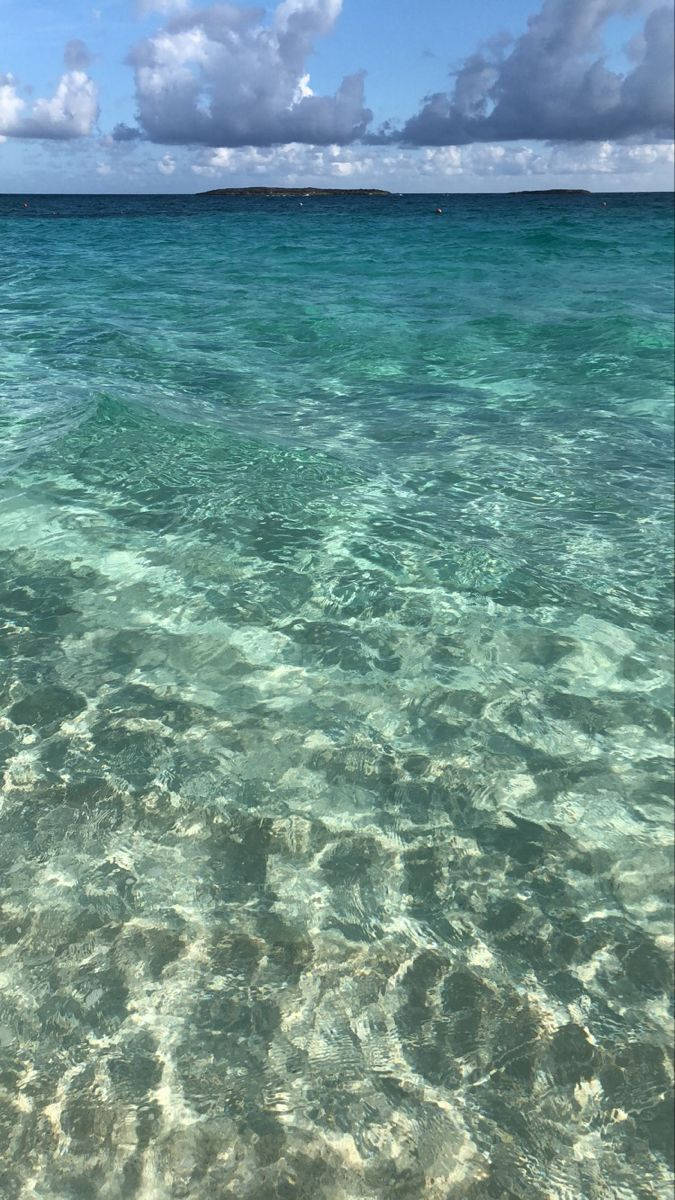 Nassau Bahamas 桌布 壁紙 — 在部分多雲的藍天下，清澈的碧綠海水在沙質海床上泛起漣漪。