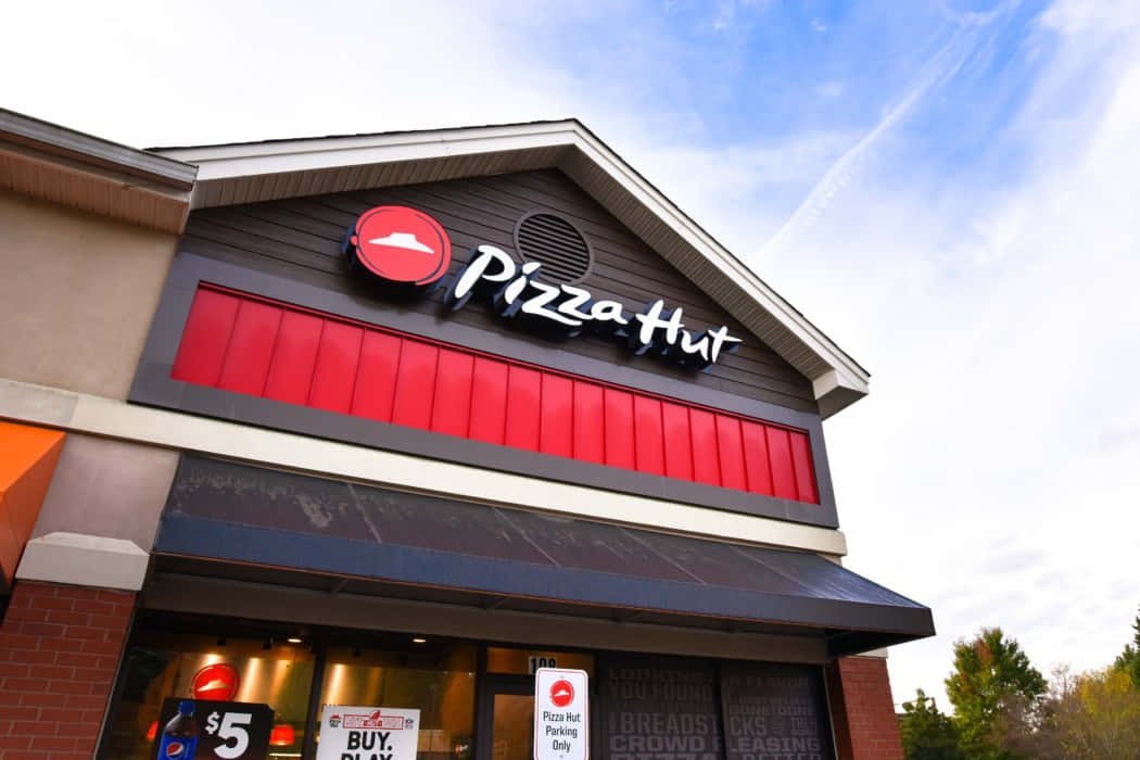 Pizza Hut餐廳外部，帶有紅色招牌和秋樹 — 必勝客 壁紙