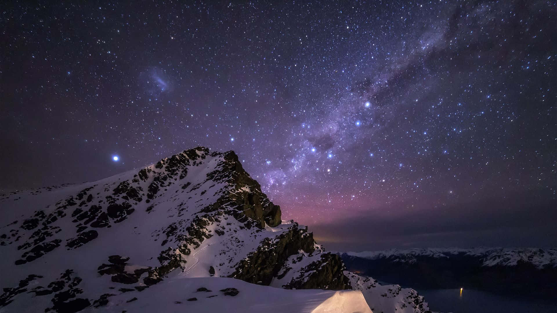 Starry Night Sky 桌布 壁紙 — 在銀河和紫色極光閃耀的璀璨星空下，積雪的山峰。
