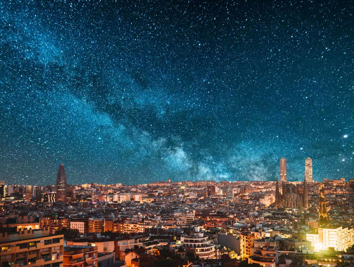 City At Night 桌布 壁紙 — 在銀河拱起的 vibrant 星空下，一片廣闊的城市景觀。