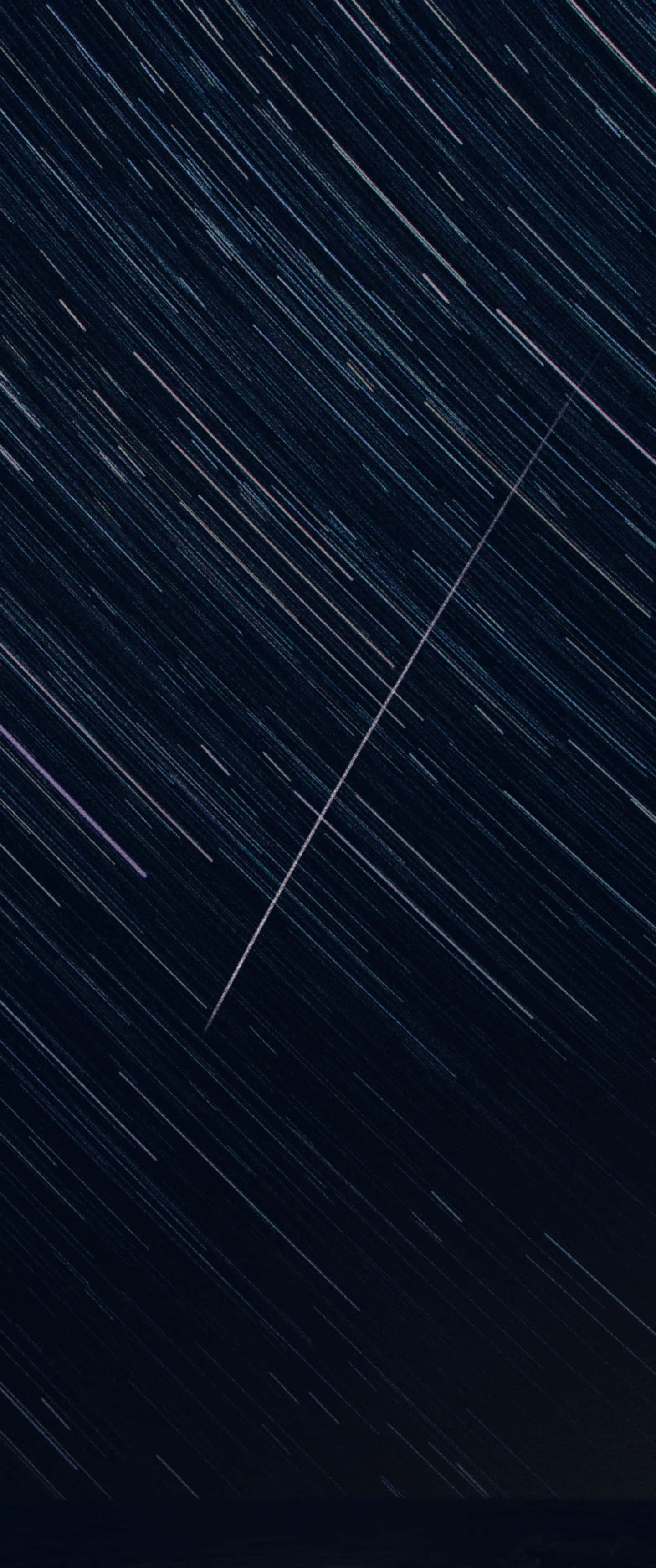 直式 桌布 壁紙 — 在長時間曝光照片中，星光條紋在深靛藍色夜空中劃出對角線路徑。