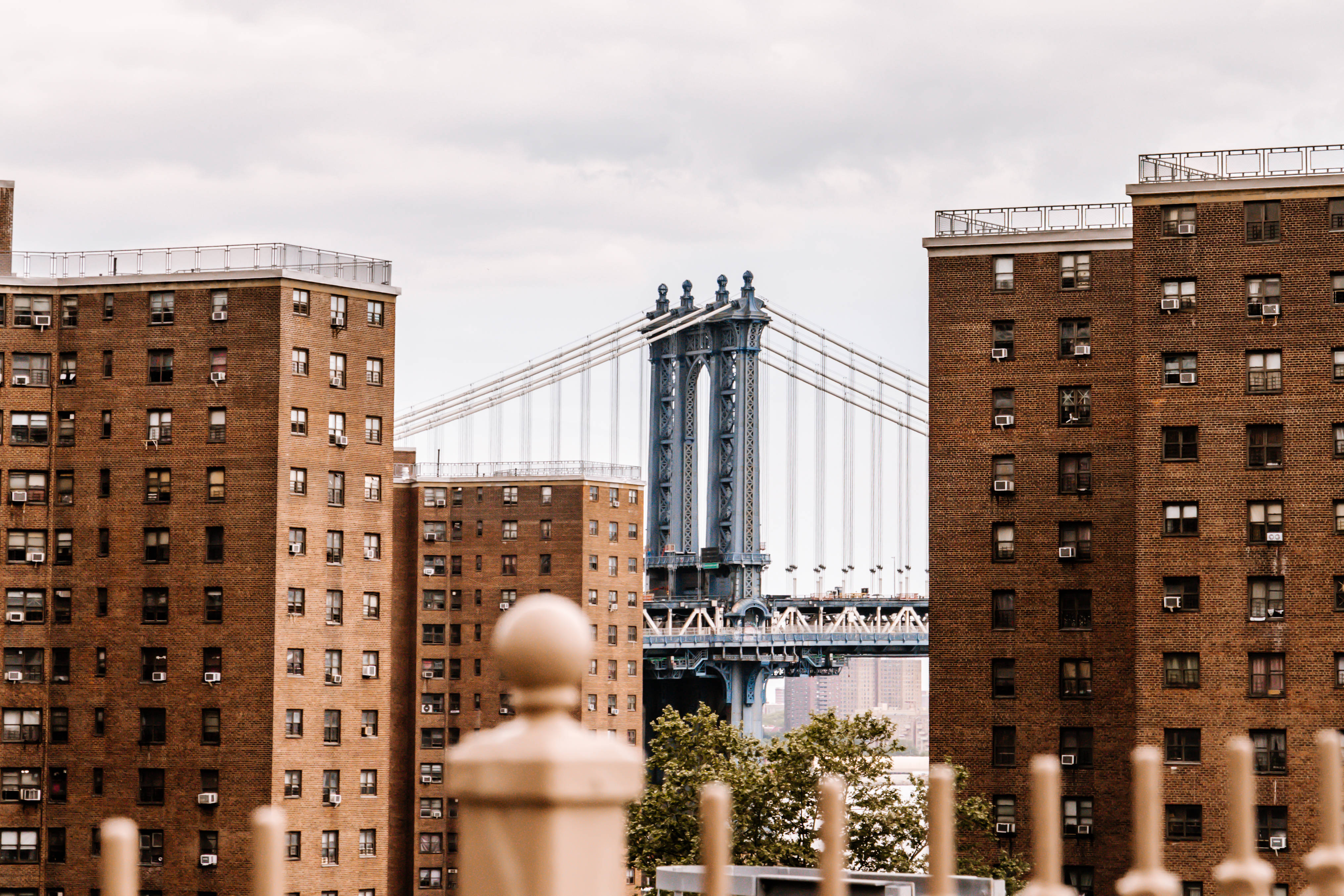Nyc Aesthetic 桌布 壁紙 — 在陰天之下，曼哈頓大橋被磚砌公寓大樓框住的景色。