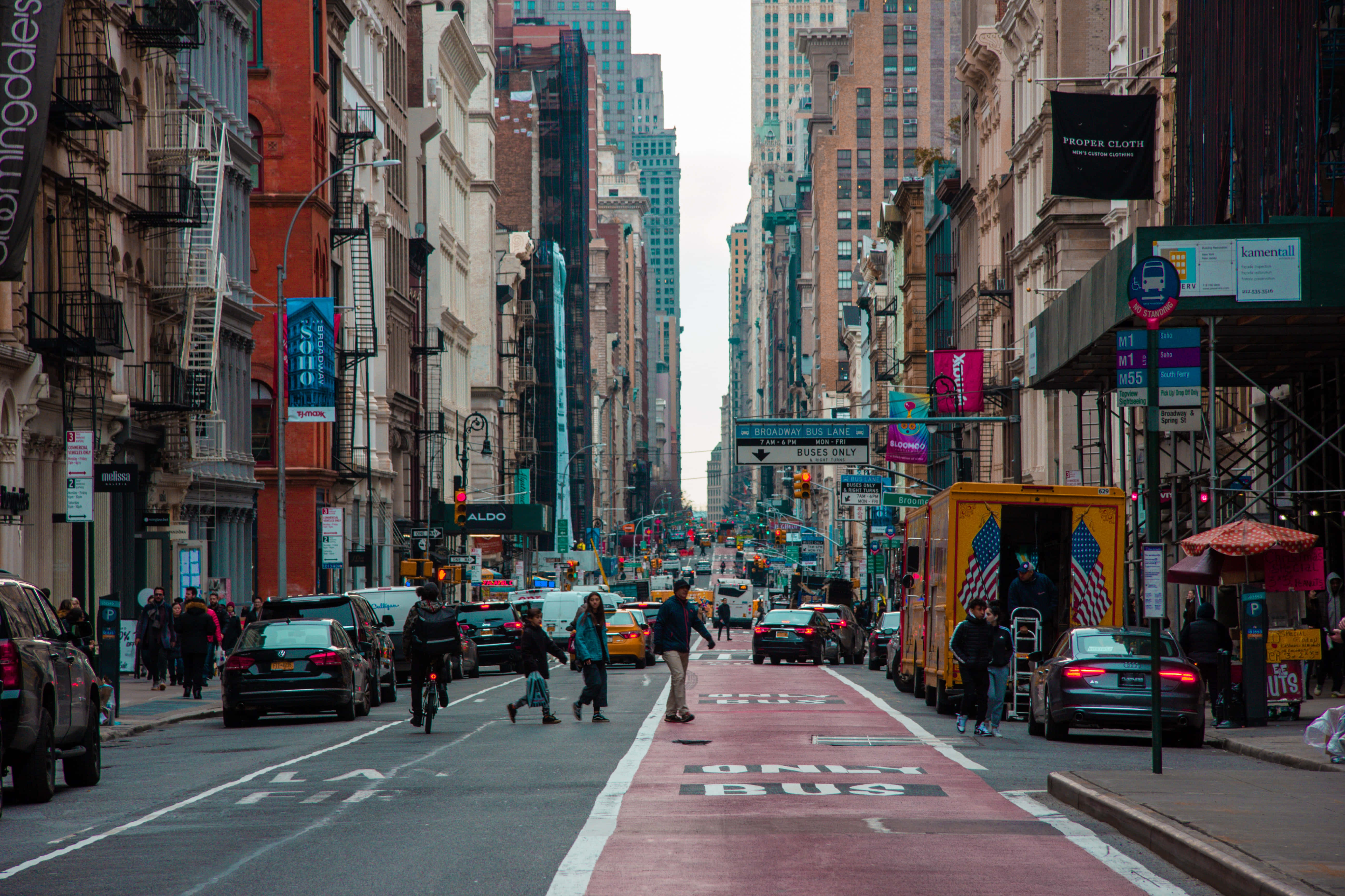 Street 桌布 壁紙 — 在陰天之下，紐約市一條繁忙的街道，高樓大廈、行人和車輛絡繹不絕。