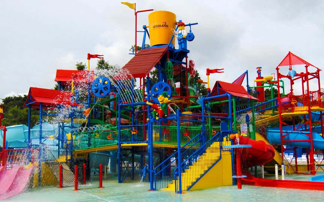 Legoland 桌布 壁紙 — 在陰天天空下，充滿活力的樂高主題水上樂園，設有色彩繽紛的滑梯和噴水。
