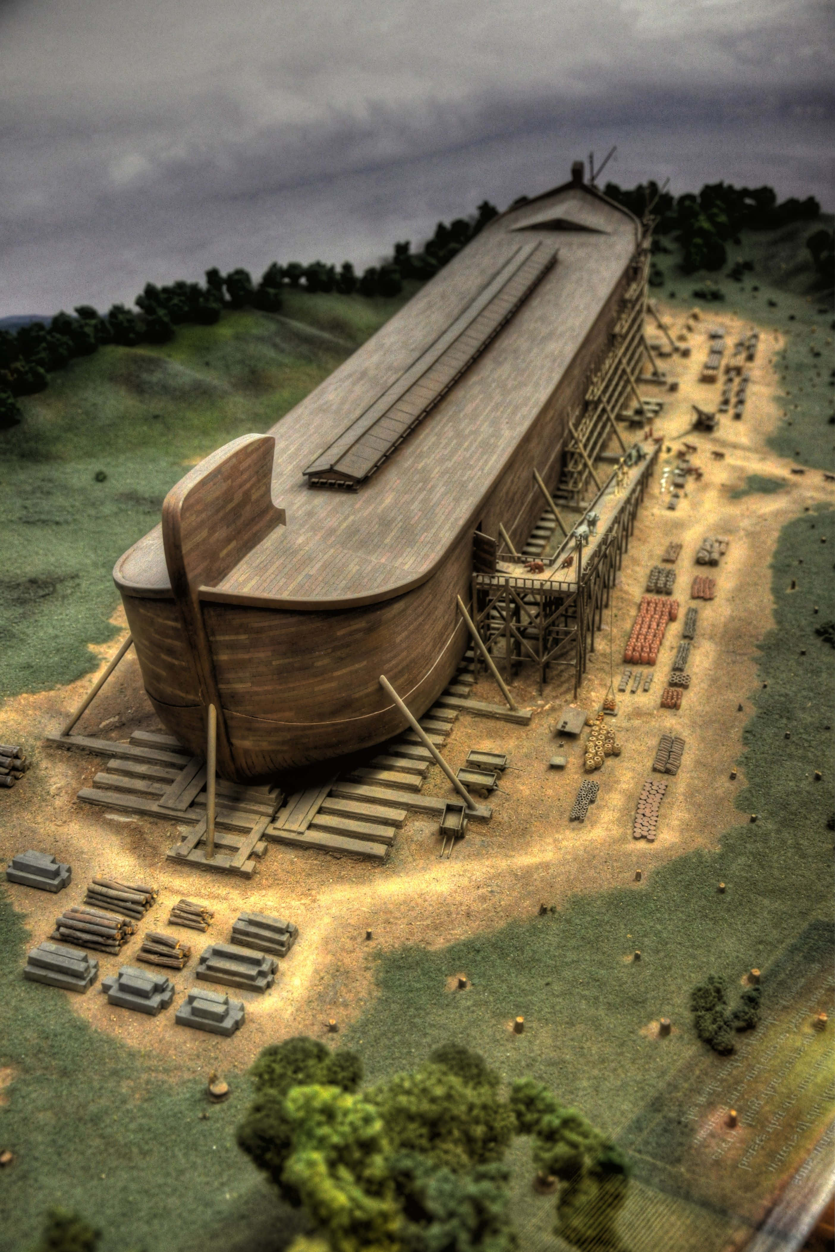 Noah's Ark 桌布 壁紙 — 在陰天天空下，山坡上正在建造一個巨大的木製方舟，周圍散落著腳手架和木材。