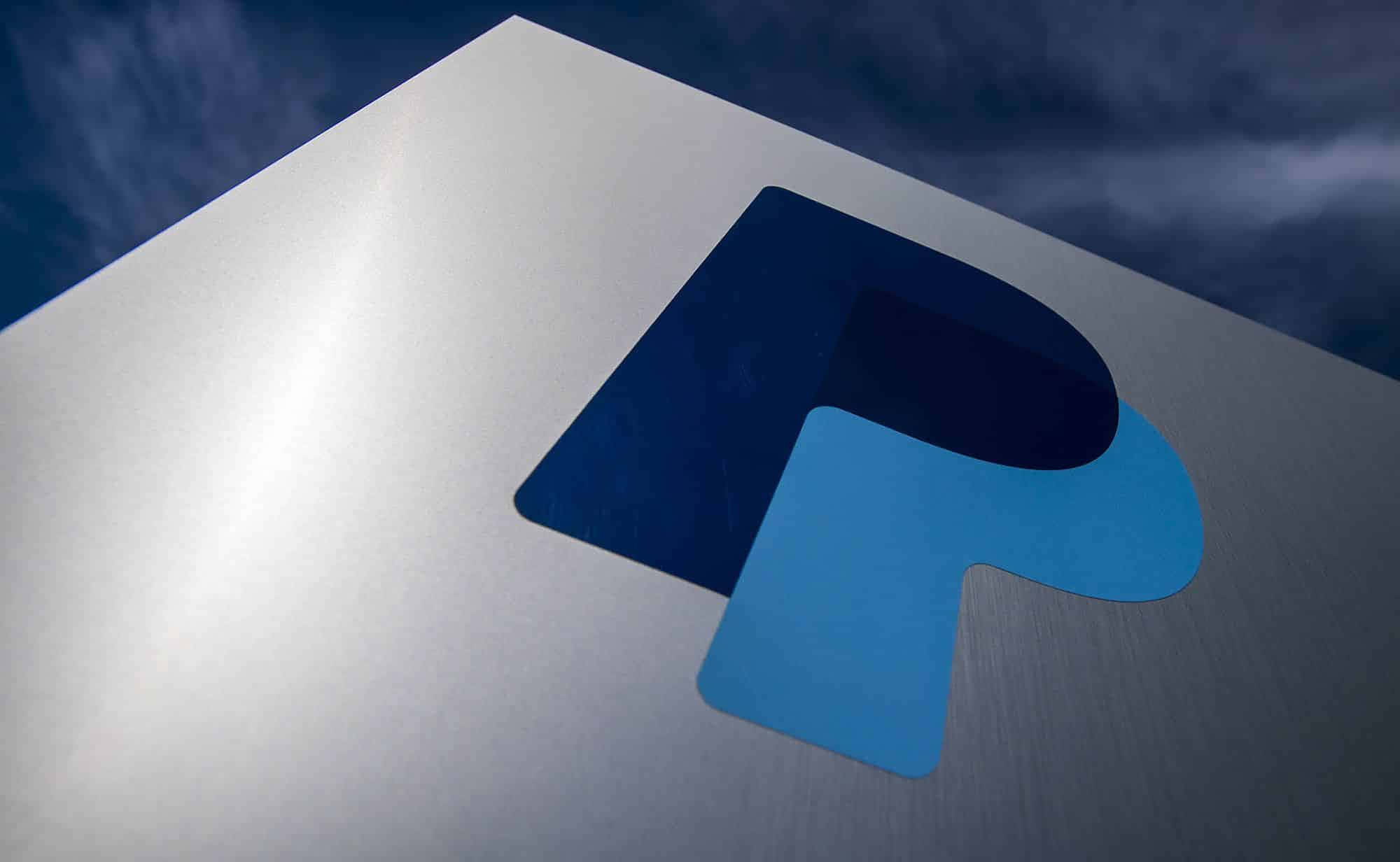 PayPal 桌布 壁紙 — 在陰天天空下，拉絲金屬表面上的藍色和深藍色PayPal標誌特寫。