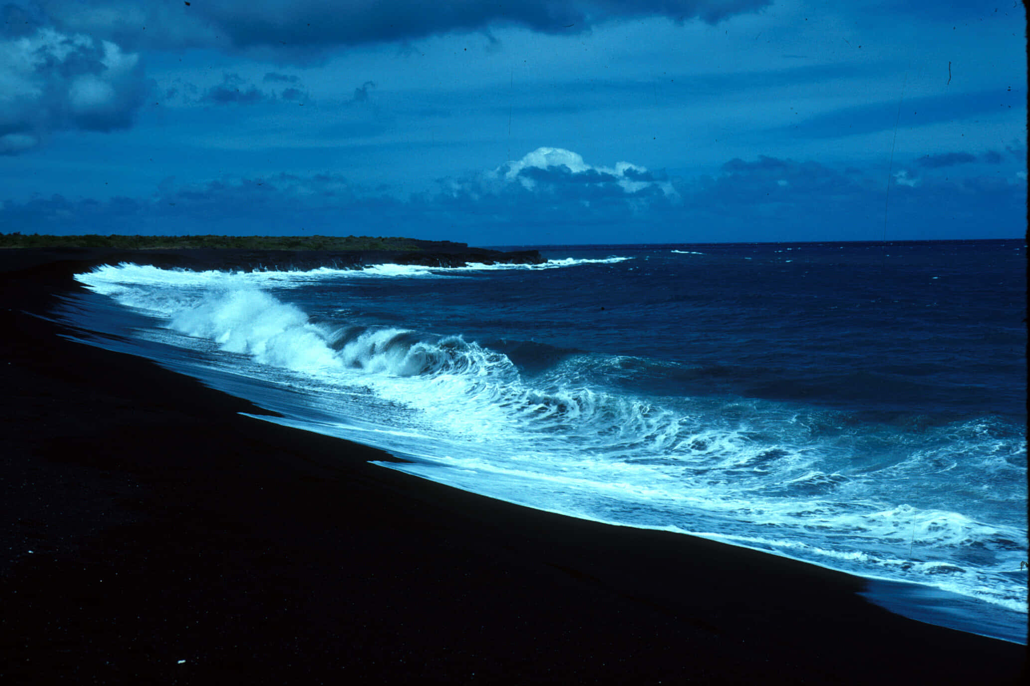 Black Sand Beach 桌布 壁紙 — 在陰沉的暮色天空下，強勁的綠松石色海浪拍打著黑色的火山沙灘。