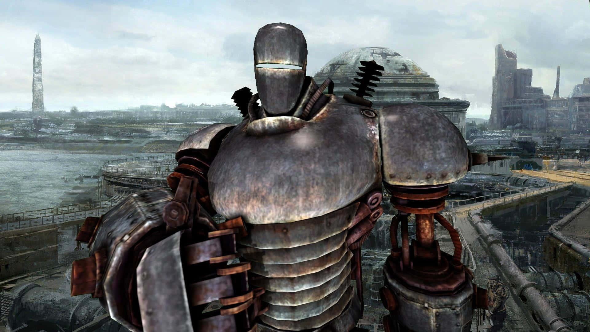 Liberty Prime 桌布 壁紙 — 在陰雲密布的天空下，一座高聳生鏽的動力裝甲矗立在荒涼的末日後城市景觀中。