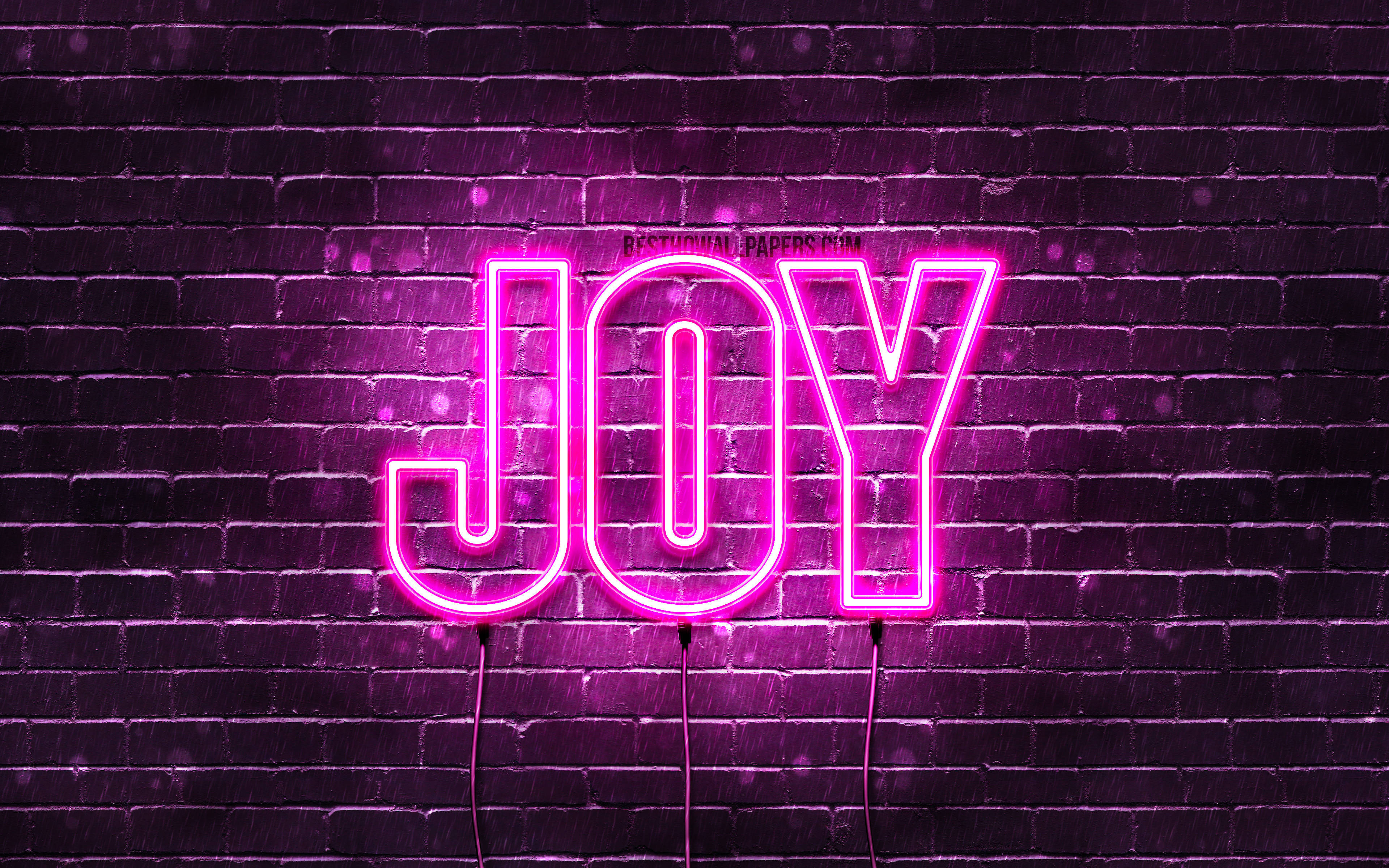 Joy 桌布 壁紙 — 在雨夜條件下，一個鮮豔的粉紅色霓虹燈牌拼寫著 JOY，在黑暗潮濕的磚牆上發光。