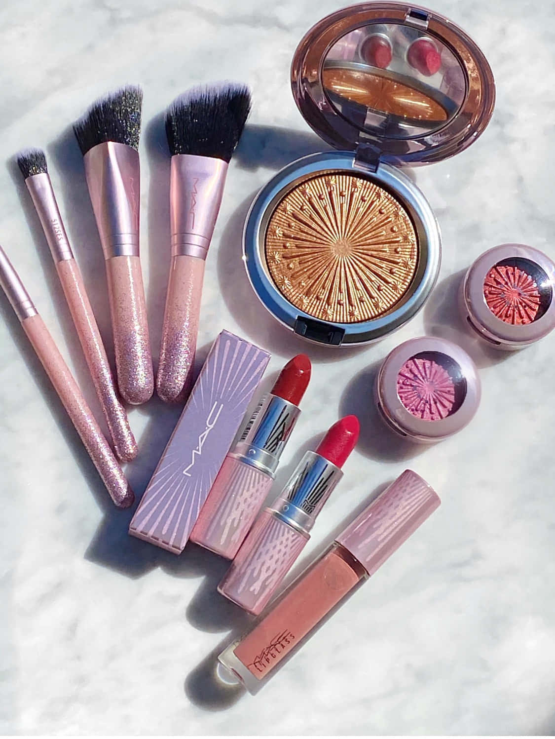 Mac Cosmetics 桌布 壁紙 — 在雲石表面上以柔和陰影展示粉紅和金色的MAC化妝品的迷人平鋪佈置。