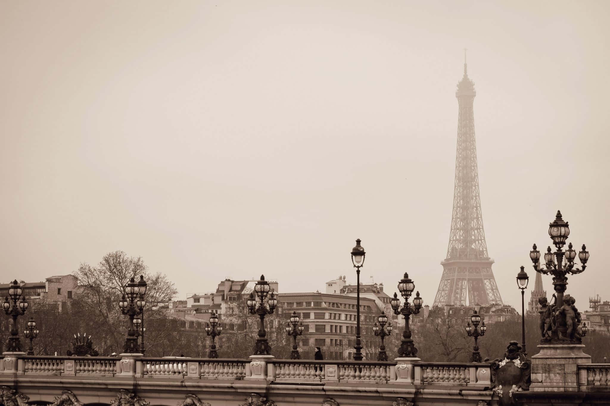 Paris Desktop 桌布 壁紙 — 在霧氣瀰漫的日子，透過華麗的燈柱和橋樑欄杆看到的棕褐色調的艾菲爾鐵塔景觀。