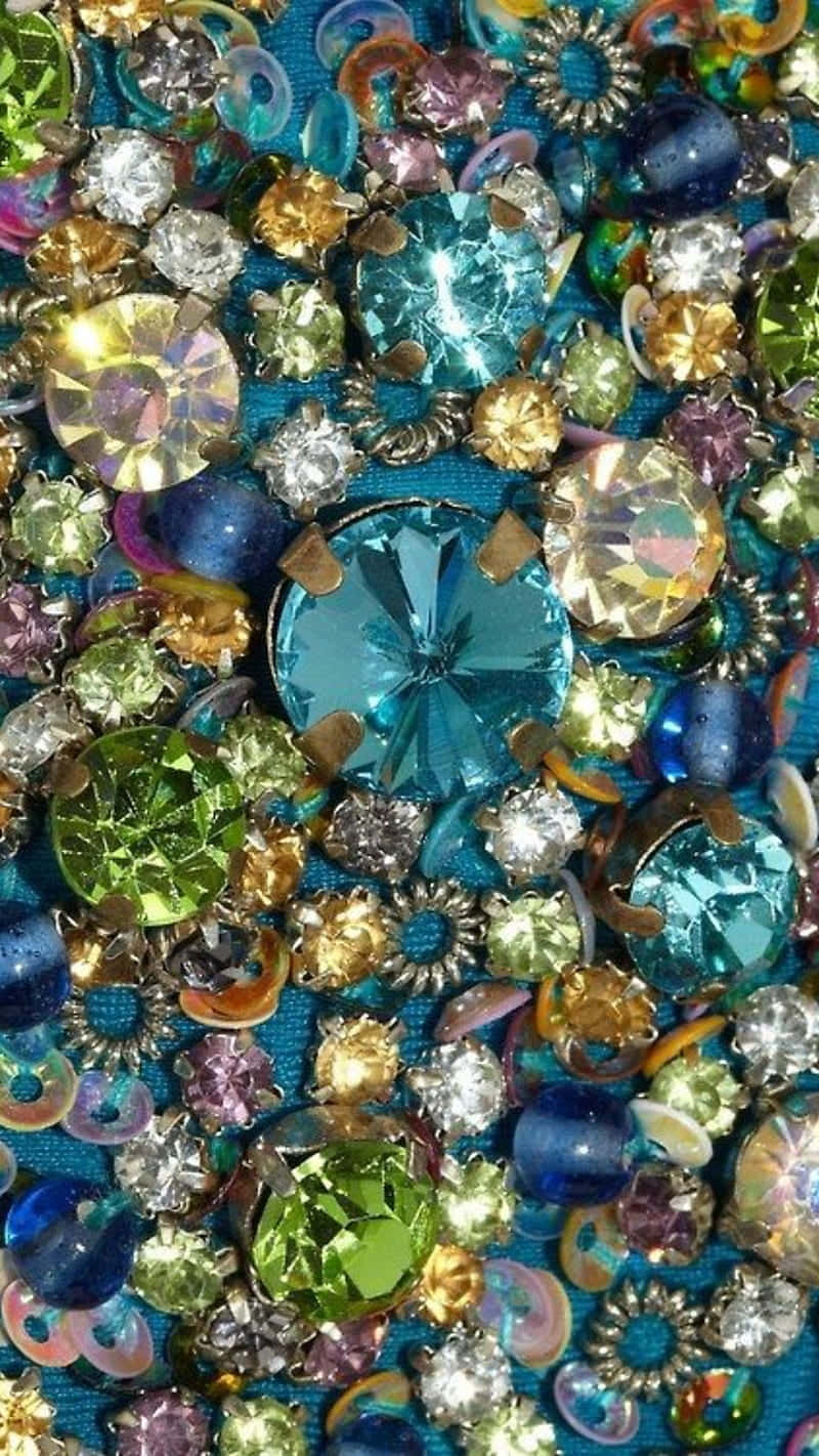 Gemstones 桌布 壁紙 — 在青綠色布料背景上，多色水鑽和亮片閃閃發光的迷人特寫。