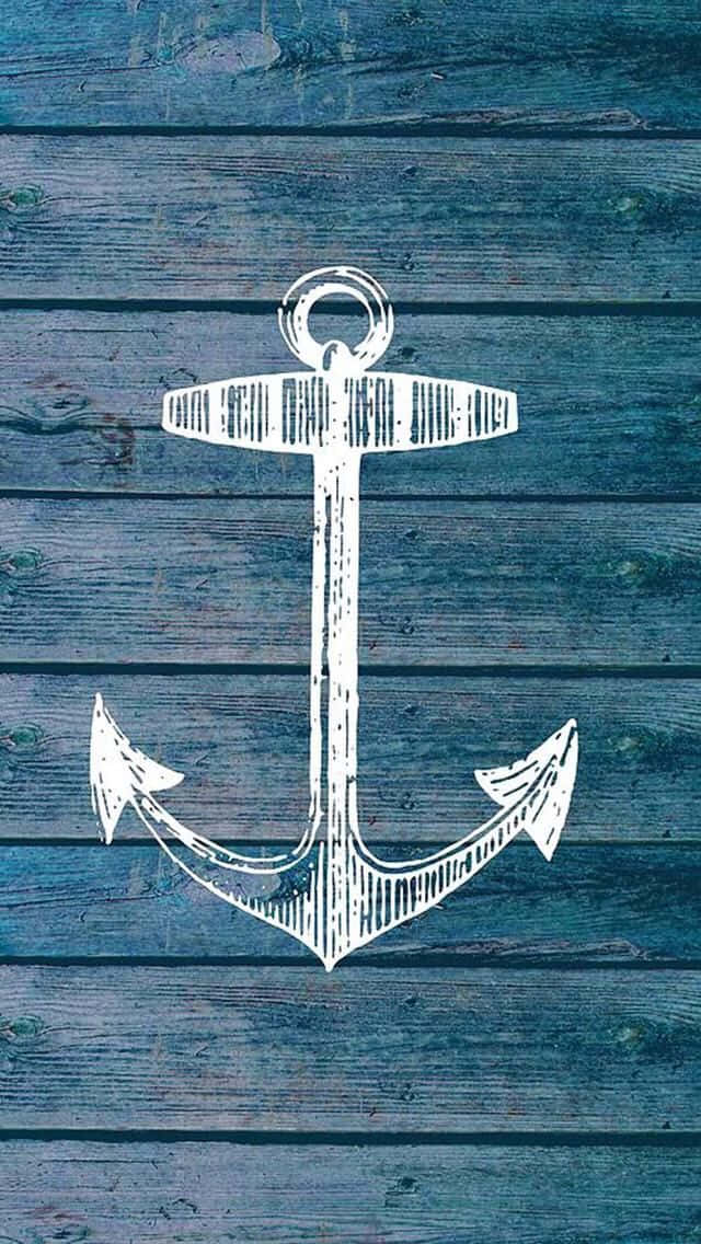 Nautical 桌布 壁紙 — 在風化的藍色木板上繪製的白色手繪錨插圖，可見木紋和質感。